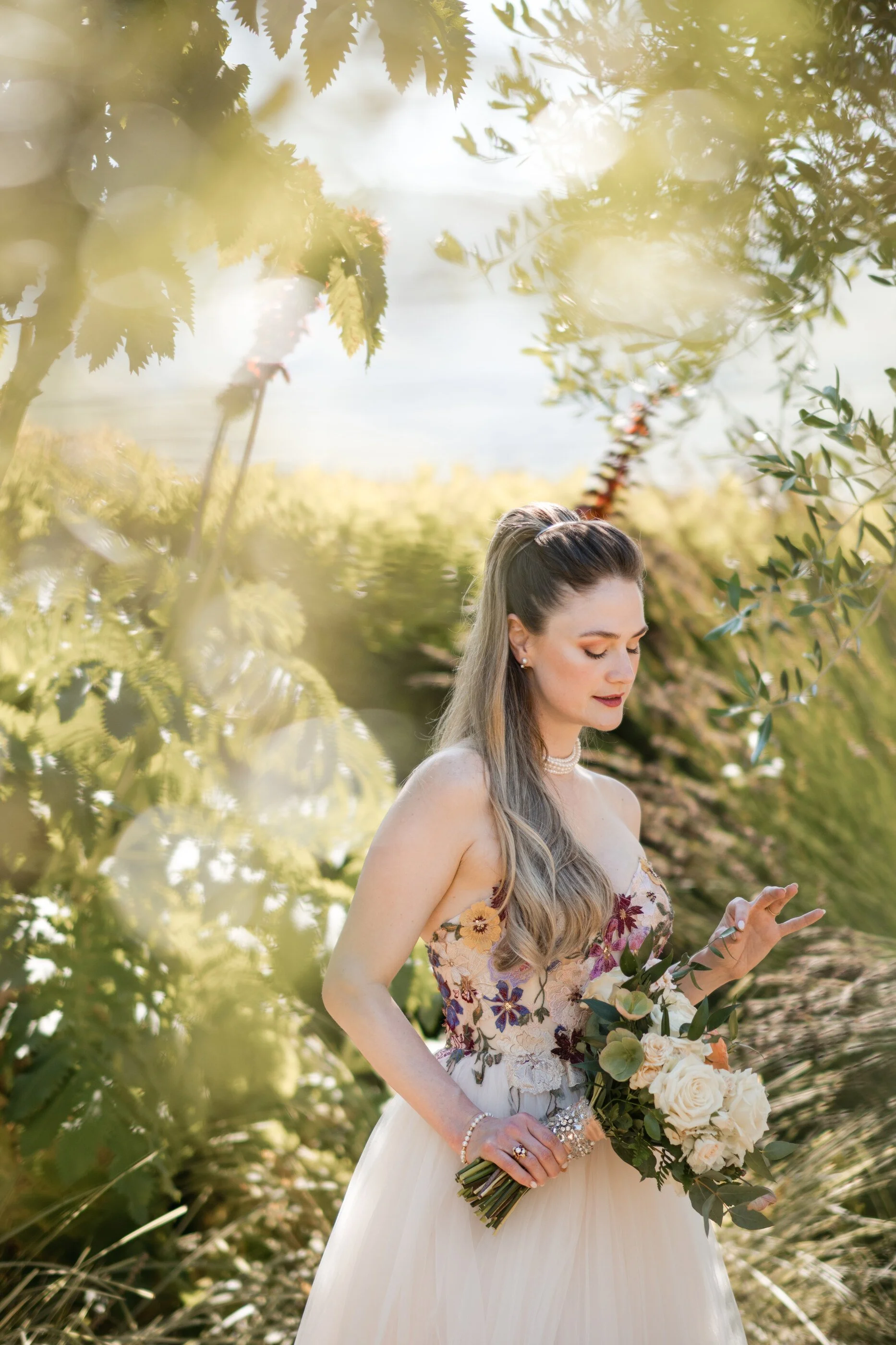 Romantic garden wedding bride portrait with soft peach, bridal makeup, glowing natural skin, floral bouquet, and embroidered wedding dress in Northern California garden setting, embroidered floral off-white wedding dress