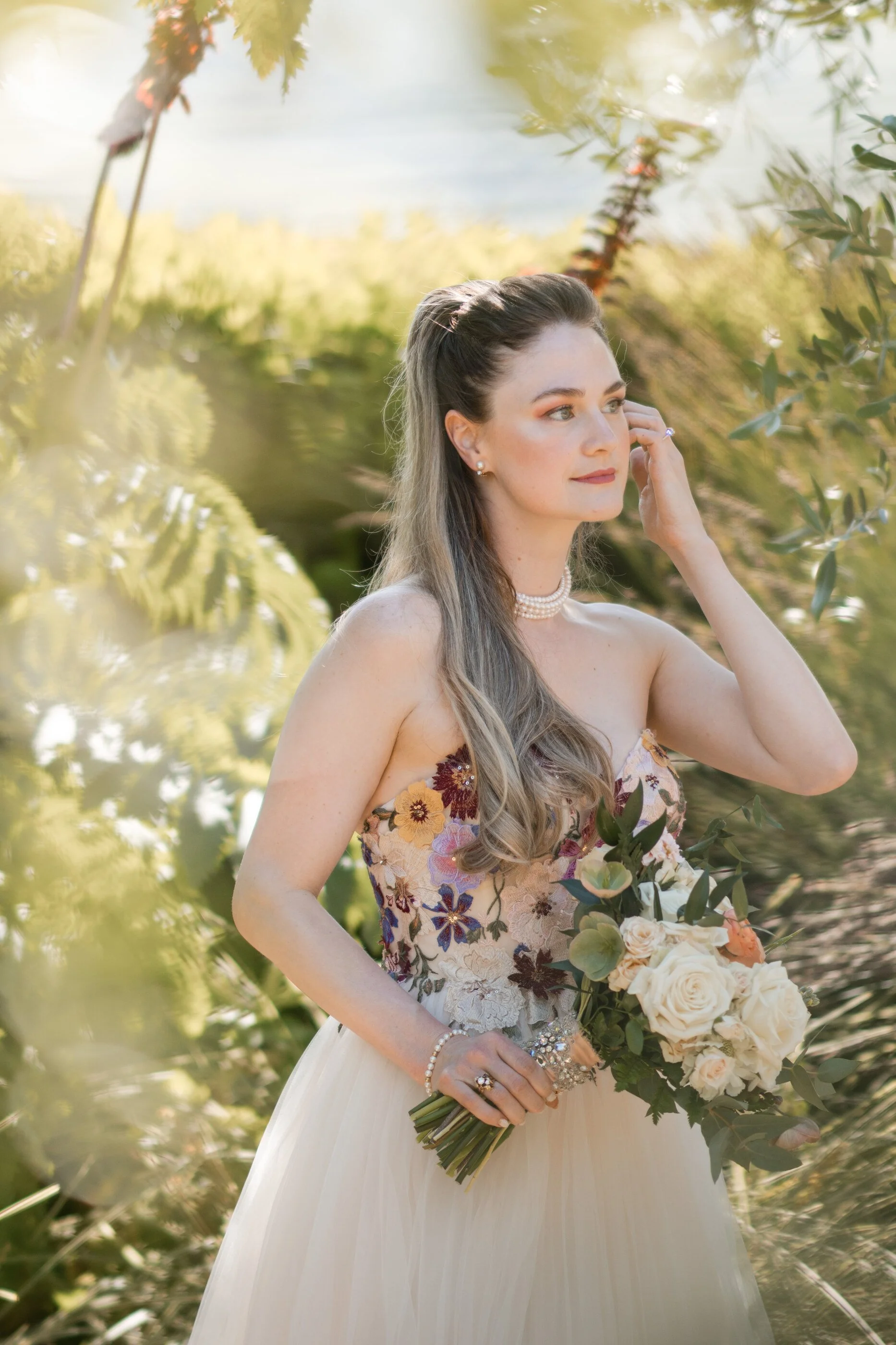 Bride holding bouquet in romantic garden wedding portrait with soft natural light. Bridal color analysis soft Autumn in the spring warm natural bridal make up. Glowing skin bridal makeup for green eyes.