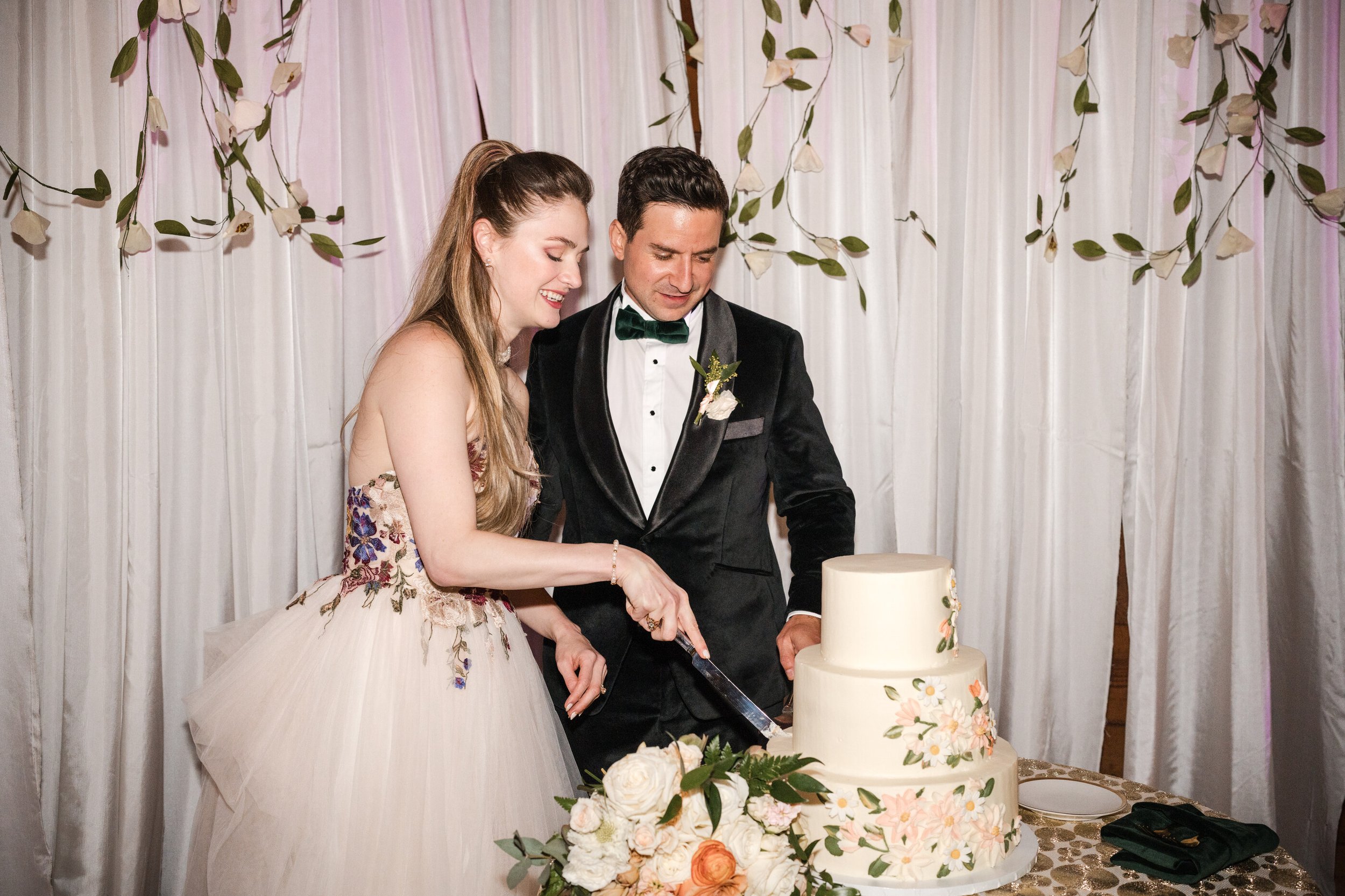 Bride and groom, cutting their wedding cake during a romantic garden reception, featuring elegant bridal hair styling and soft, natural wedding makeup. A joyful cake cutting moment at a romantic garden wedding, showcasing, timeless, bridal hair and g