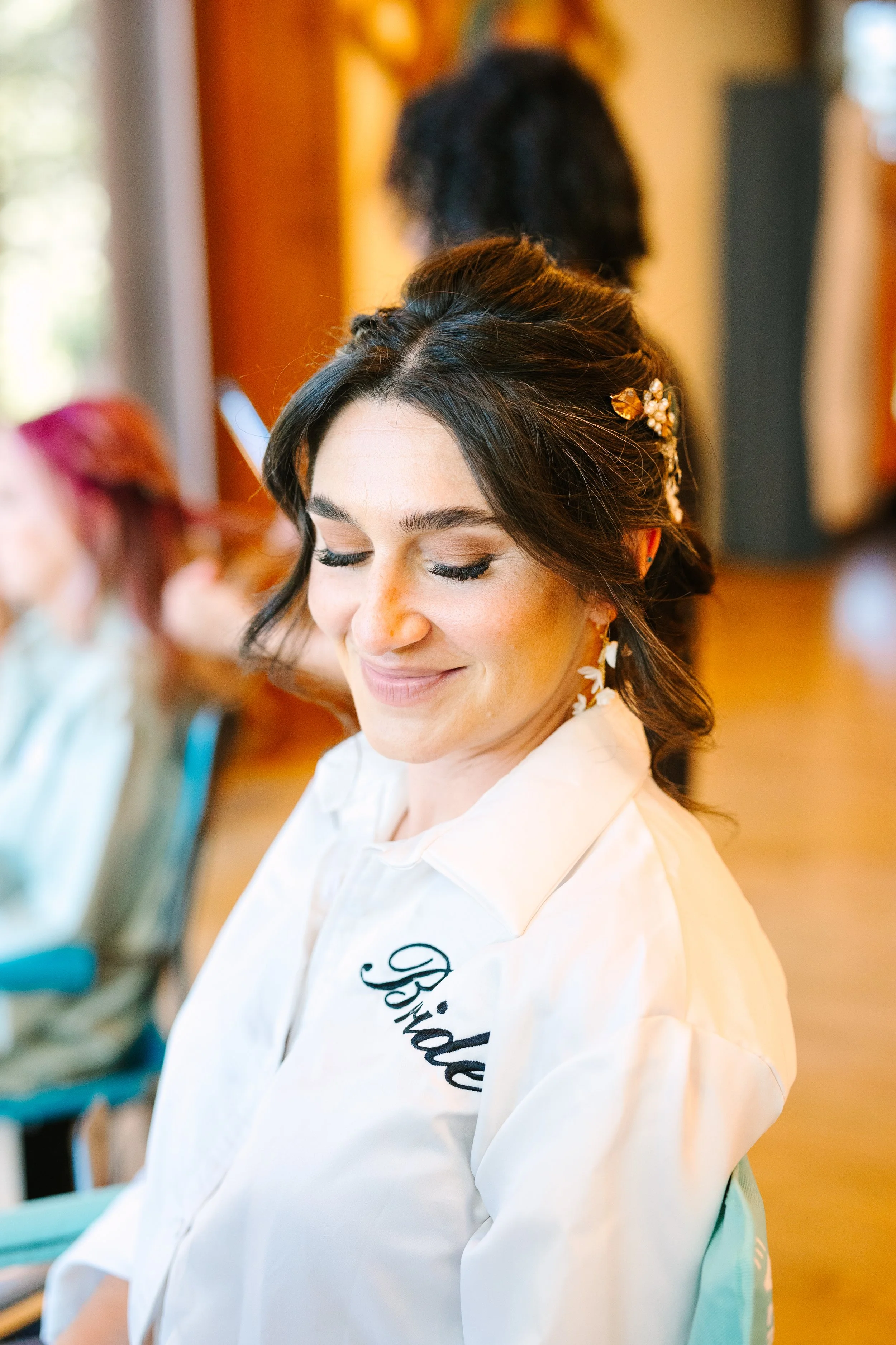 Bride with soft, natural bridal makeup and romantic updo during redwood forest wedding getting ready moment by Beauty by Santi. Natural make up bride, romantic, textured up style wedding hair for thick hair make up for deep-set eyes.