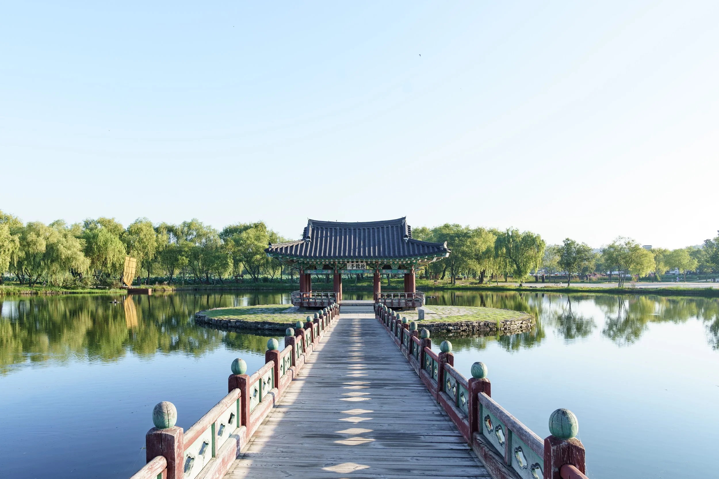 bridge-that-goes-lake-up-traditional-building-surrounded-by-forest-south-korea.jpg