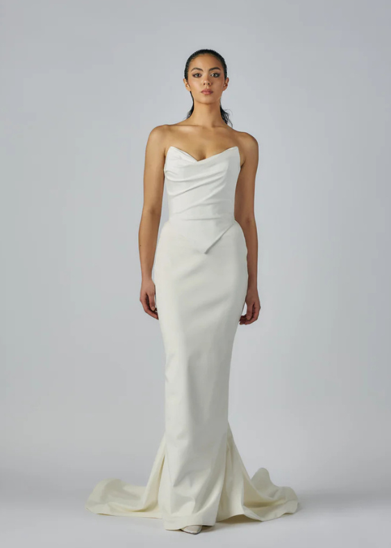 Picture of a contemporary bride wearing a modern, sleek bridal skirt standing tall with a minimalist background