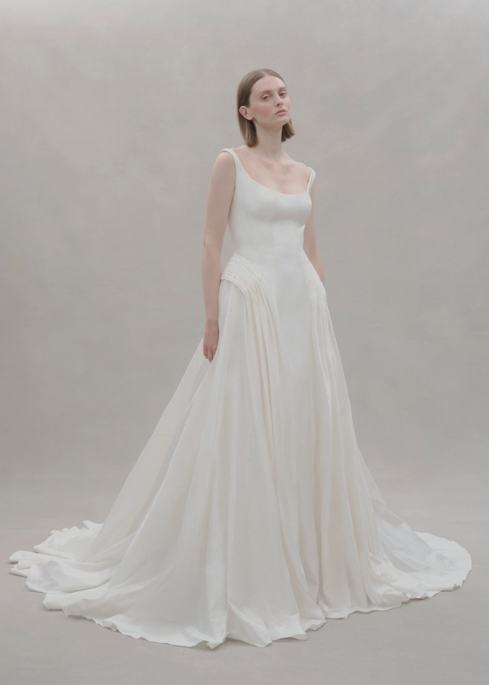 High-fashion Australian bridal gown showcasing a wide scoop neckline and pleated hip detail