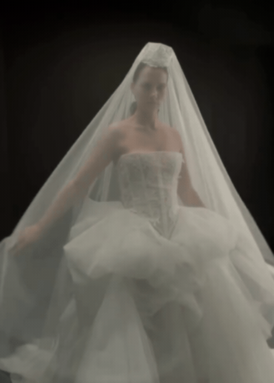 Video of a modern Australian Bride standing on a black background with a contemporary bridal veil and basque waist lace corset with boning.