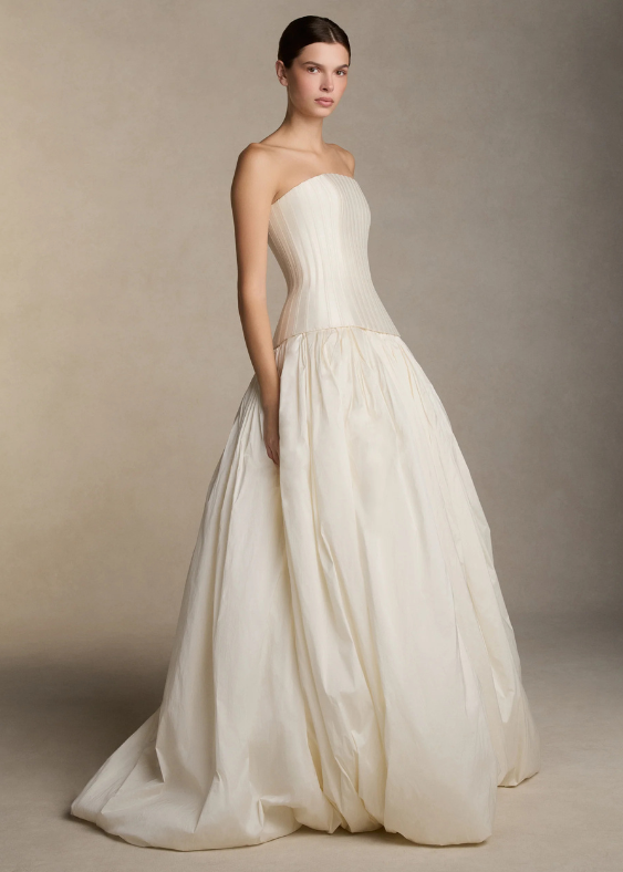 A woman seen from the side wearing a contemporary wedding skirt with a basque yoke waiste and bubble hem by Danielle Frankel, exclusively stocked at Bloom Australia.