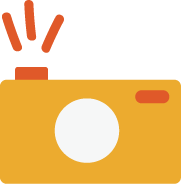 A yellow camera with a flash on top and a white lens on the front.