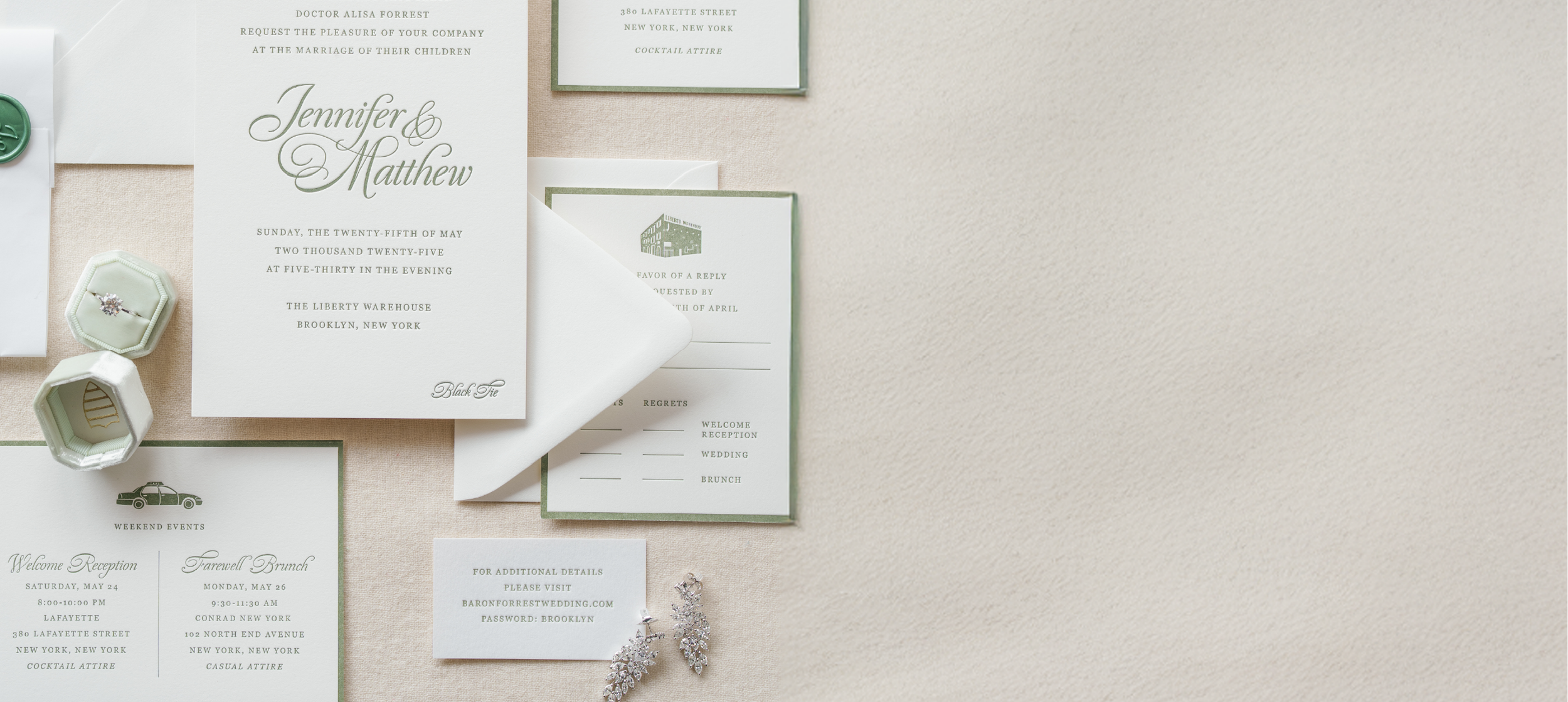 Wedding invitation suite with a main card featuring the names 'Jennifer & Matthew', surrounded by smaller cards, a pair of earrings, and a ring in a jewelry box, all laid out on a light-colored surface.