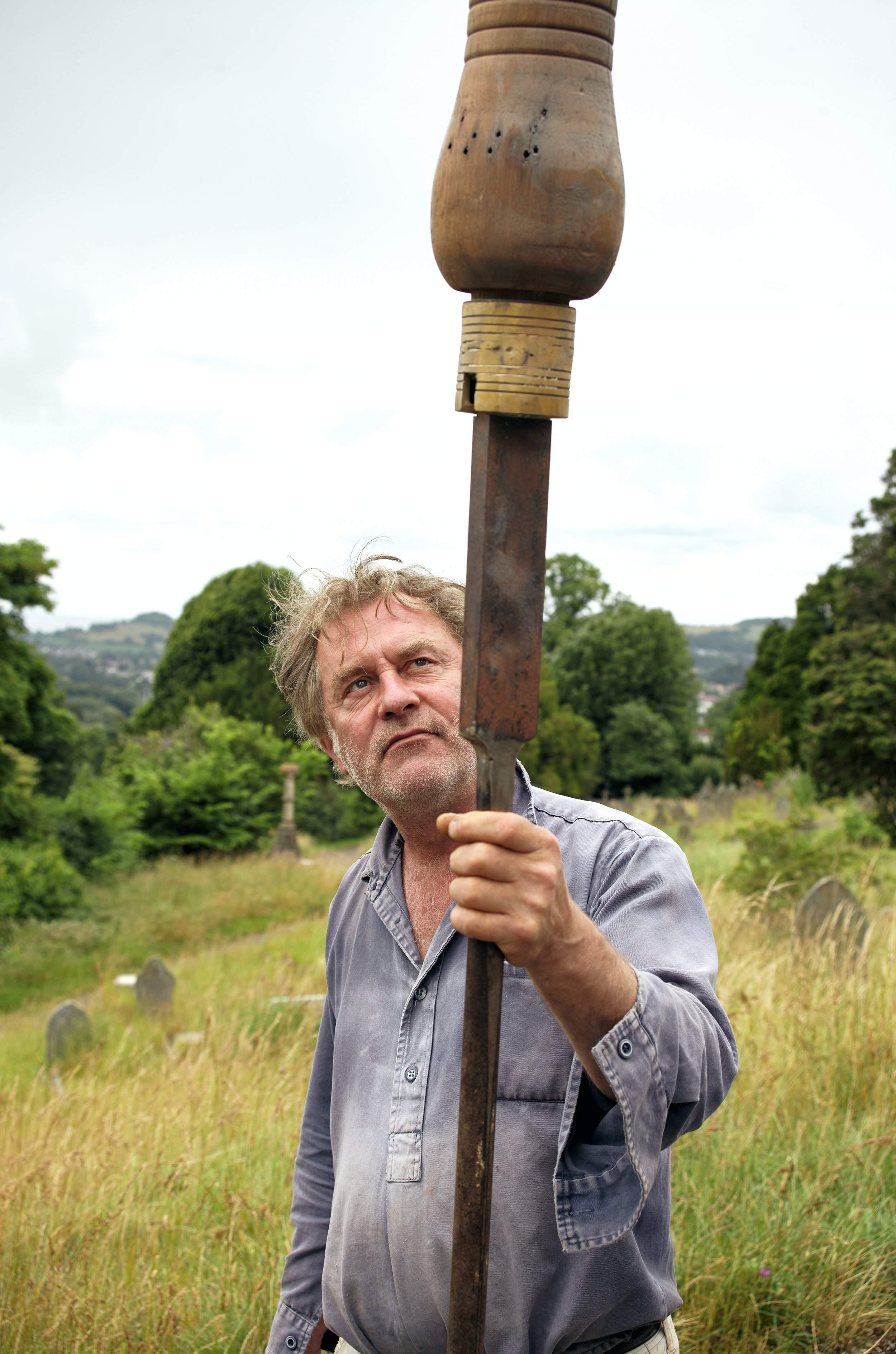 Portrait photograph of Paul Grellier artist holding large screwdriver on top of a hill taken by photographer Hatty Frances Bell