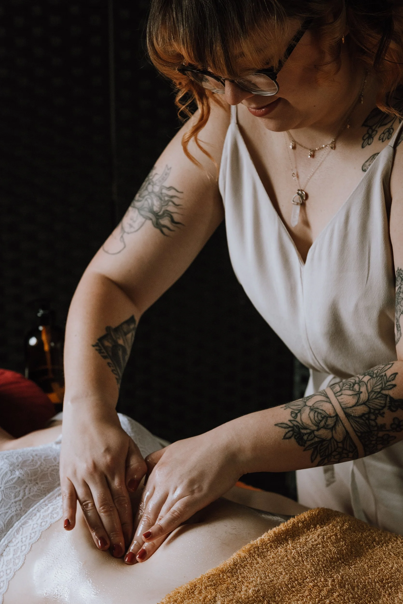 Massage therapist. She is dressed in white and is massaging a stomach.