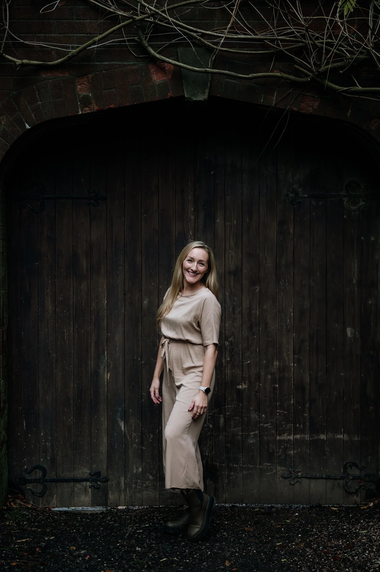April Wild, Wild & Wild events standing in front of a large wooden gate, she is smiling to the camera.