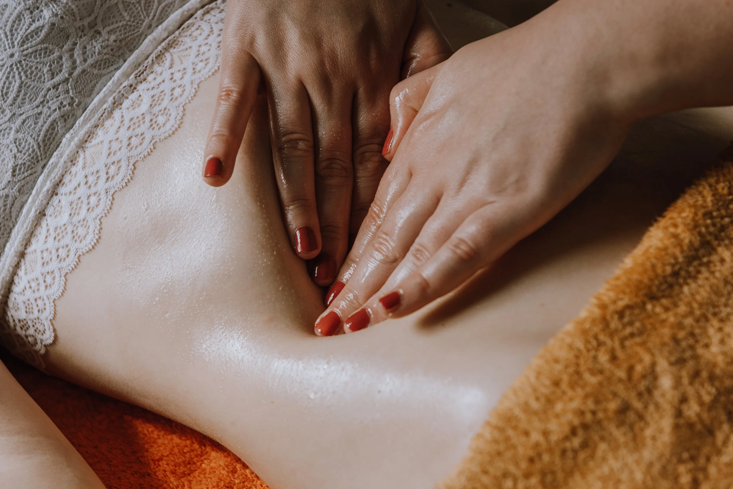 Close up of hands massaging a woman's stomach.