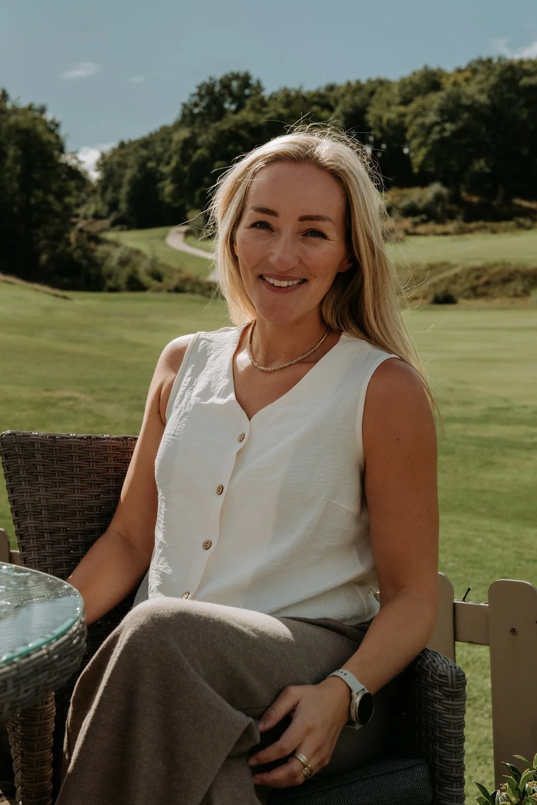 April Wild, Wild & Wild events. April is sat outdoors on a bright summer day, she is looking relaxed and smiling at the camera.