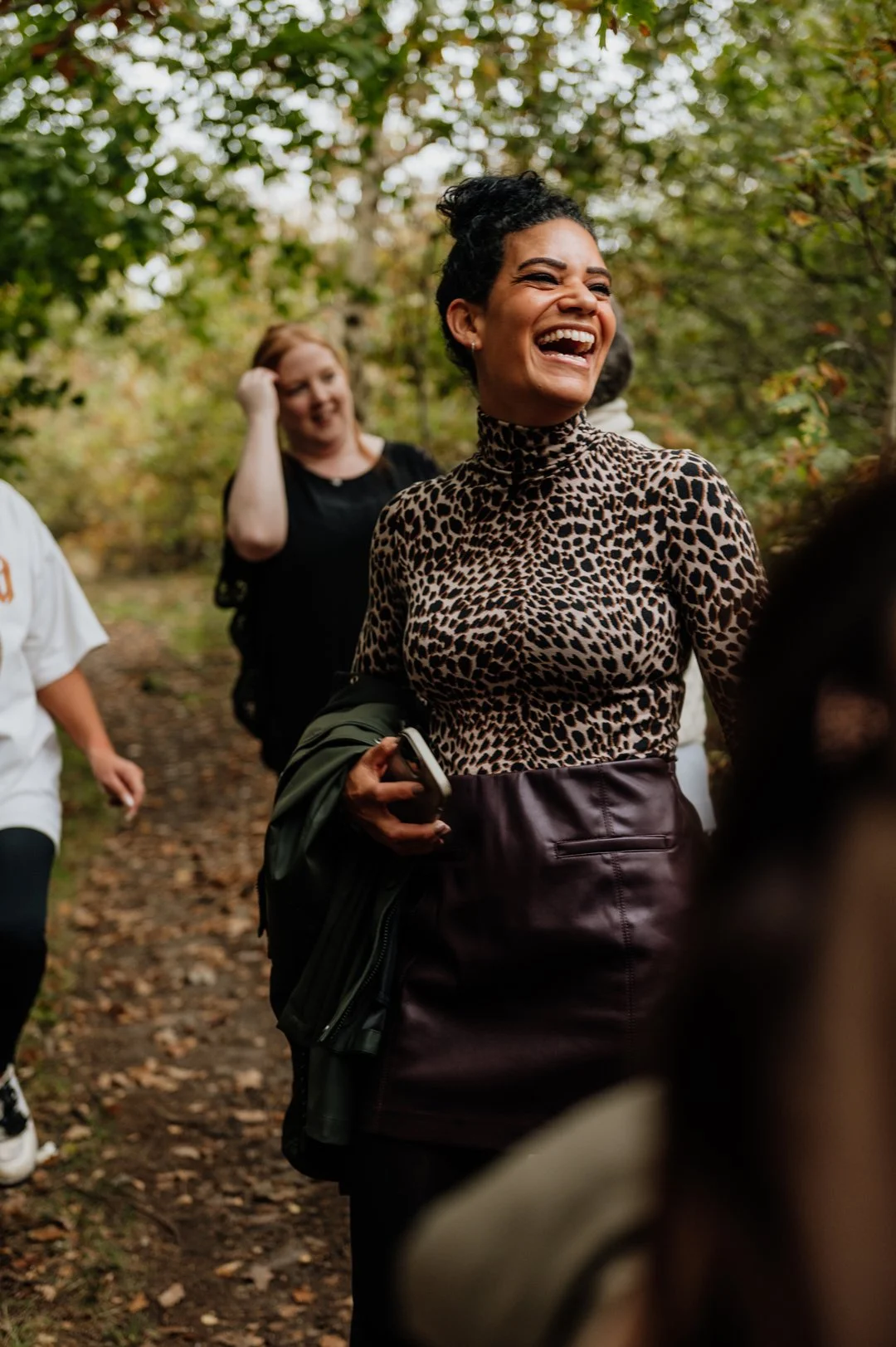 Nina, Nurtured Through Nature. She is smiling with a group of women around her in the woods.