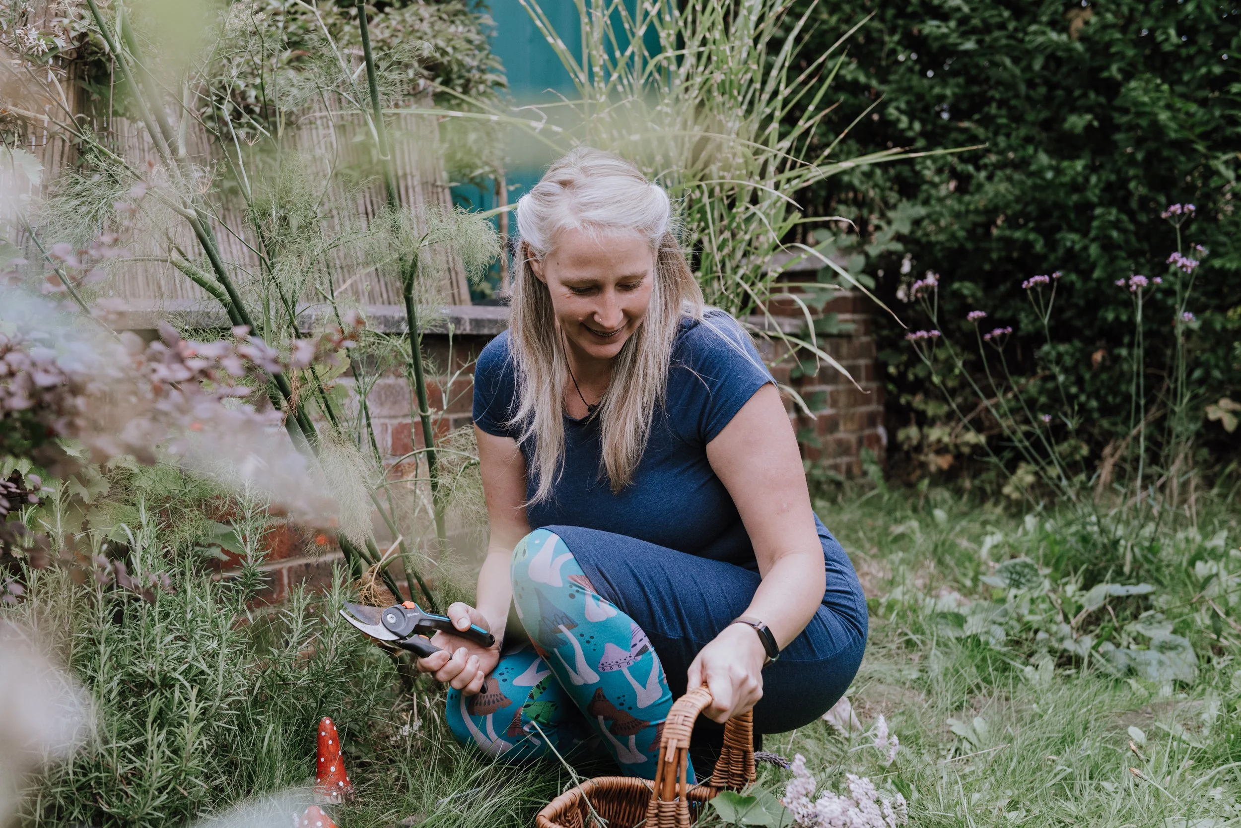Carly, Nature In Me. Carly is dressed in blue and collecting plants from her garden.