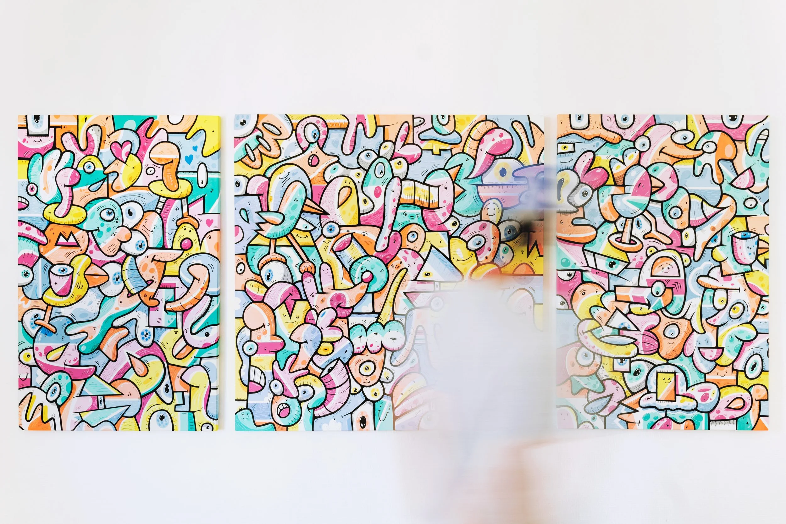 L'artiste français Jigé dans son studio devant son oeuvre triptyque colorée et joyeuse