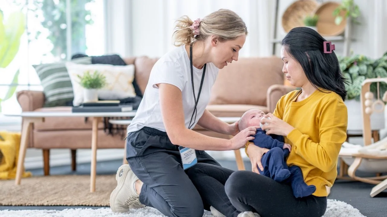 lactation consultant helping a mother nurse her baby