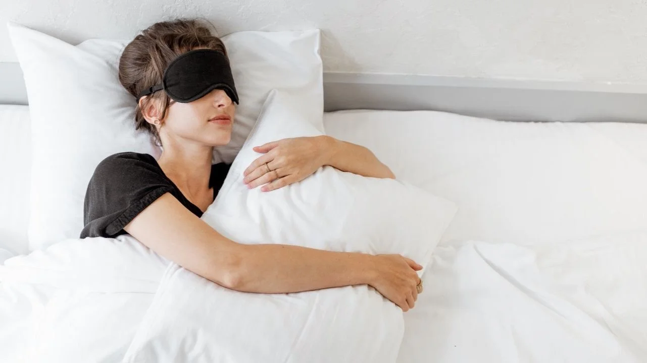 woman sleeping in bed wearing eye mask