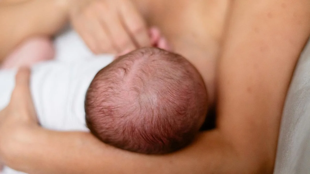 woman breast feeding her infant