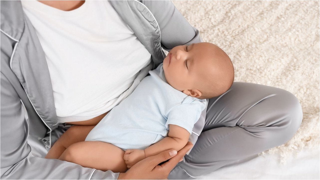 woman holding sleeping baby