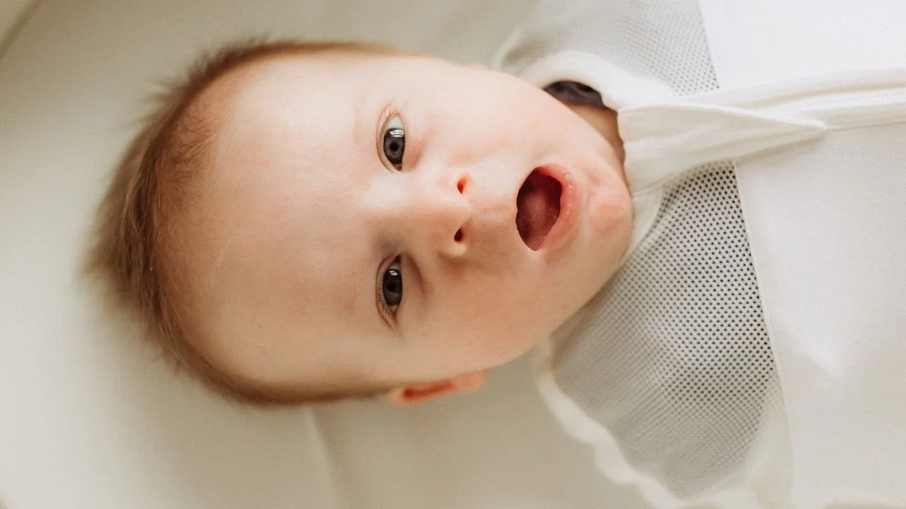 baby yawning in bassinet