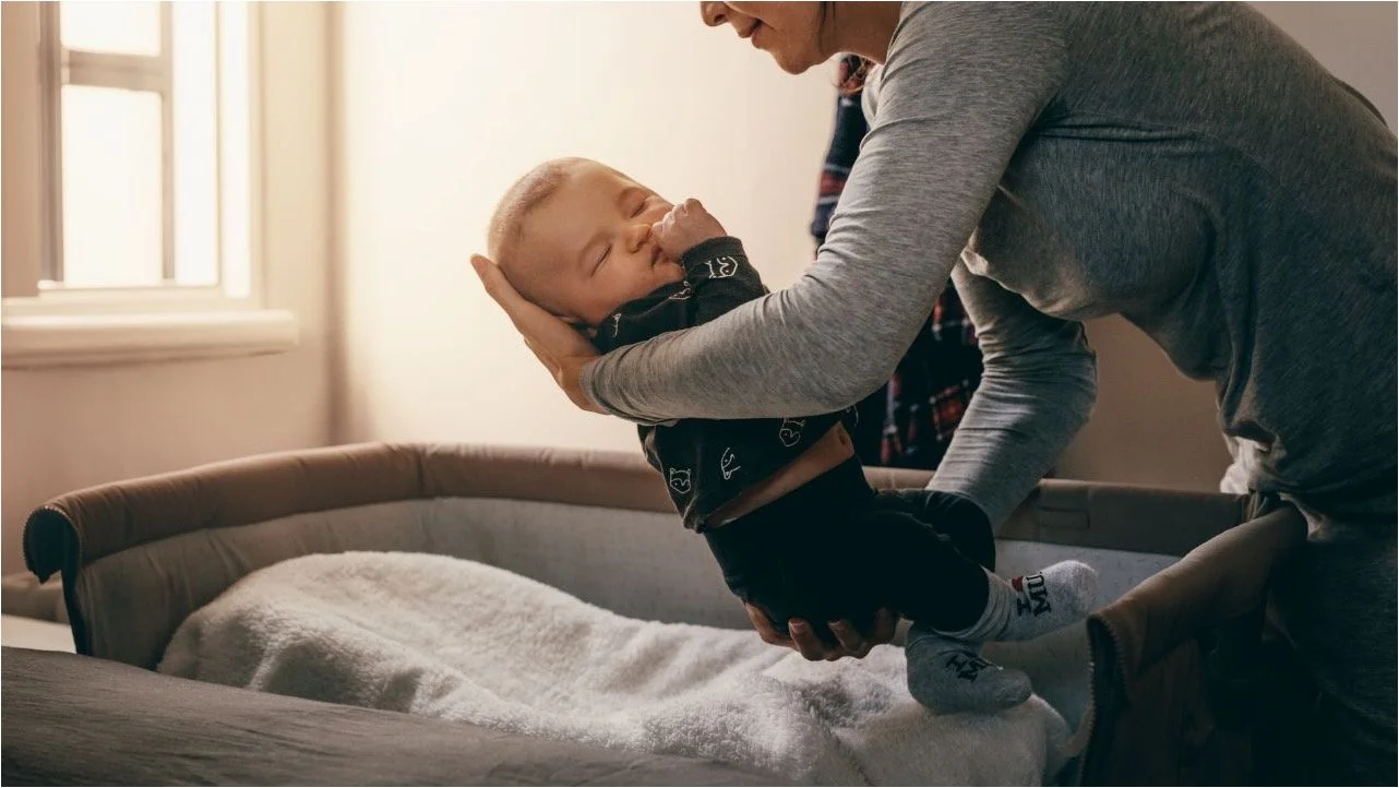 putting sleeping baby in bassinet