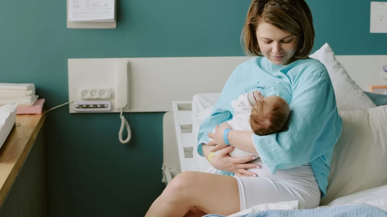 postpartum woman in hospital breastfeeding baby