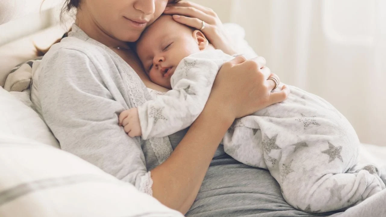 woman holding sleeping baby