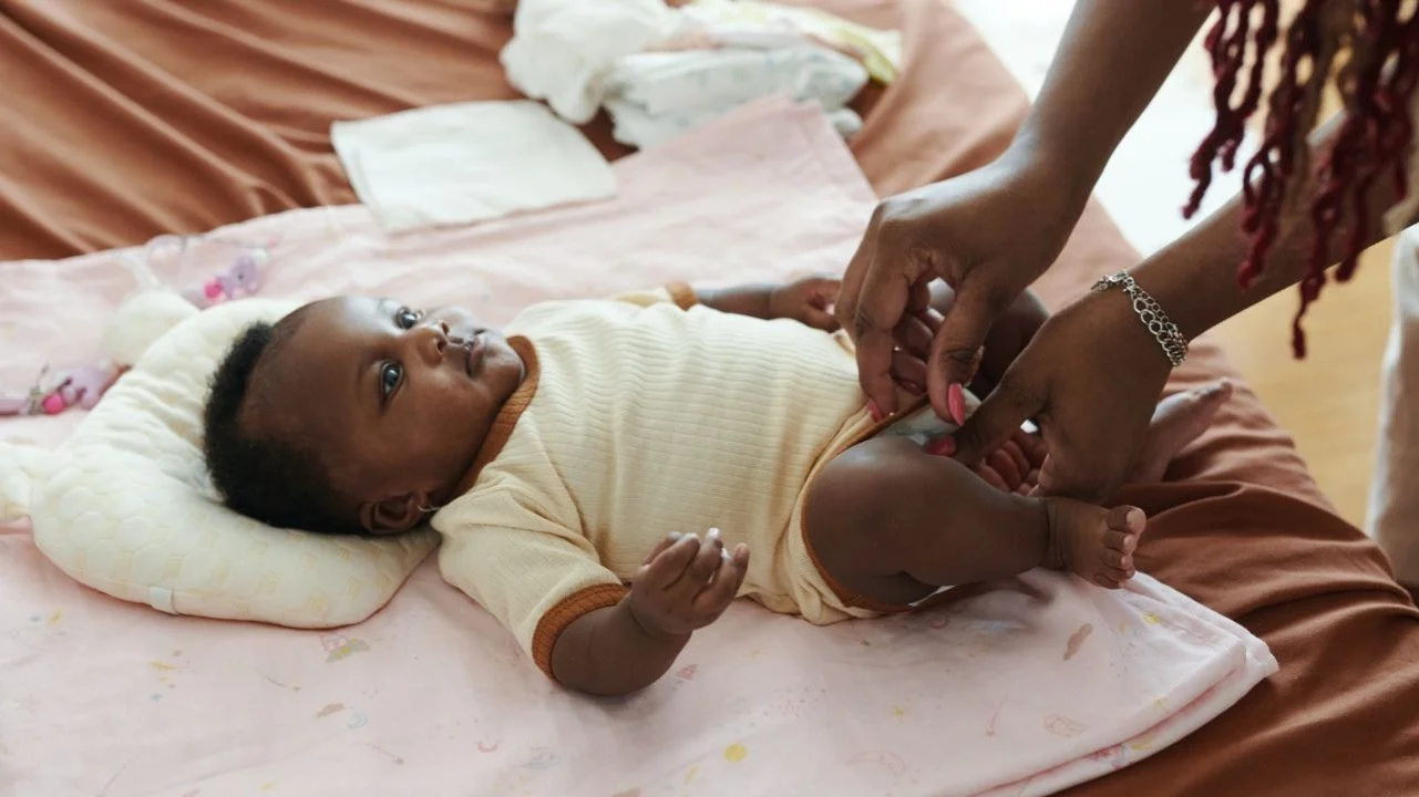 woman changing a baby's diaper