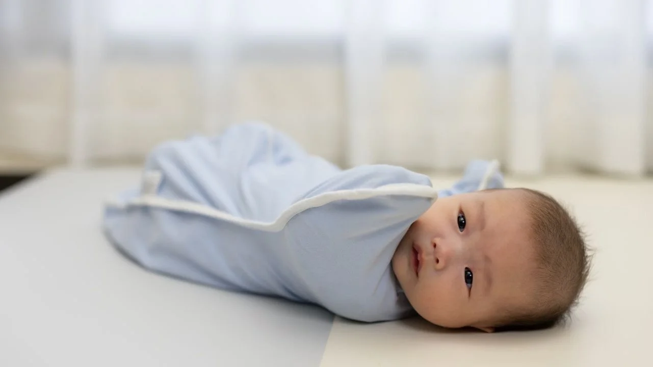baby swaddled in crib