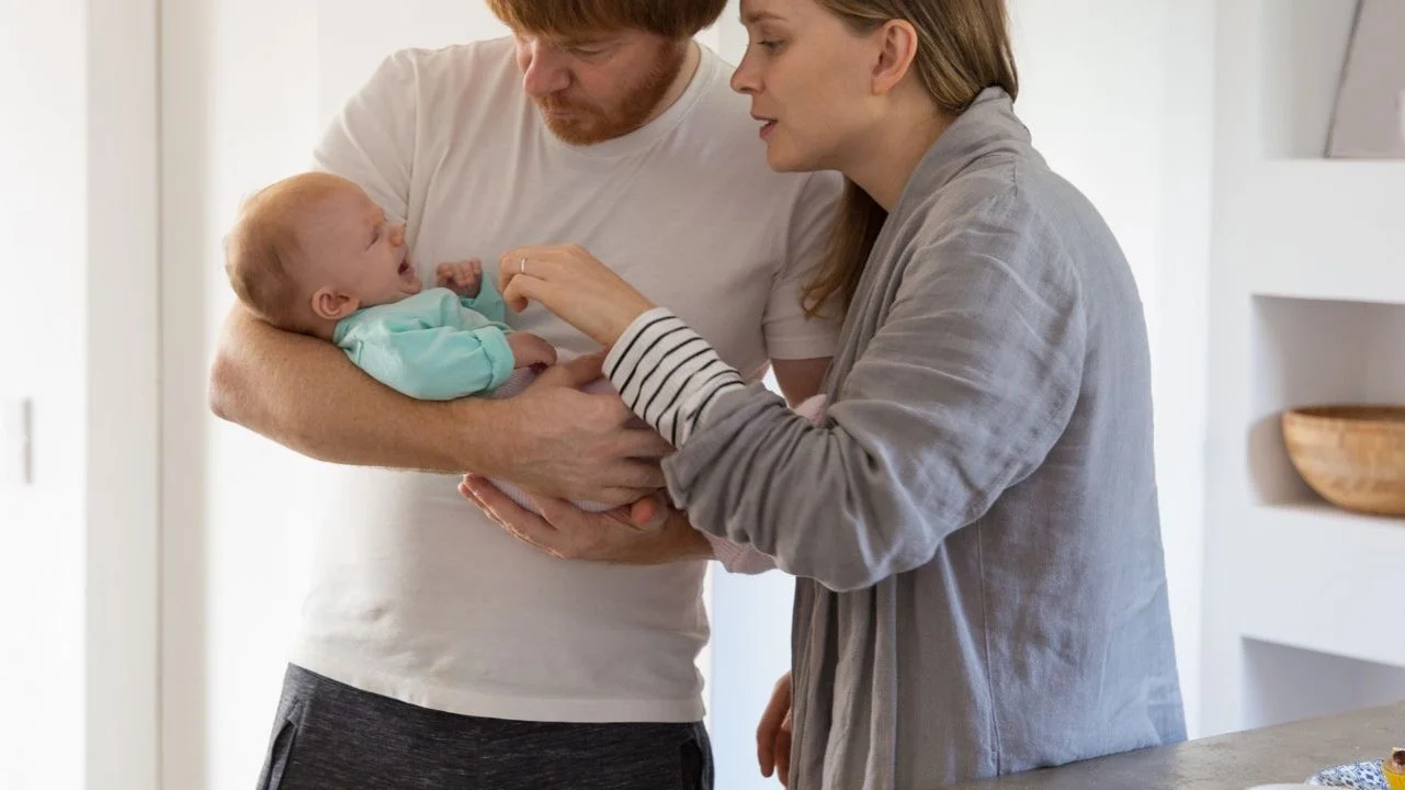 parents holding a crying baby