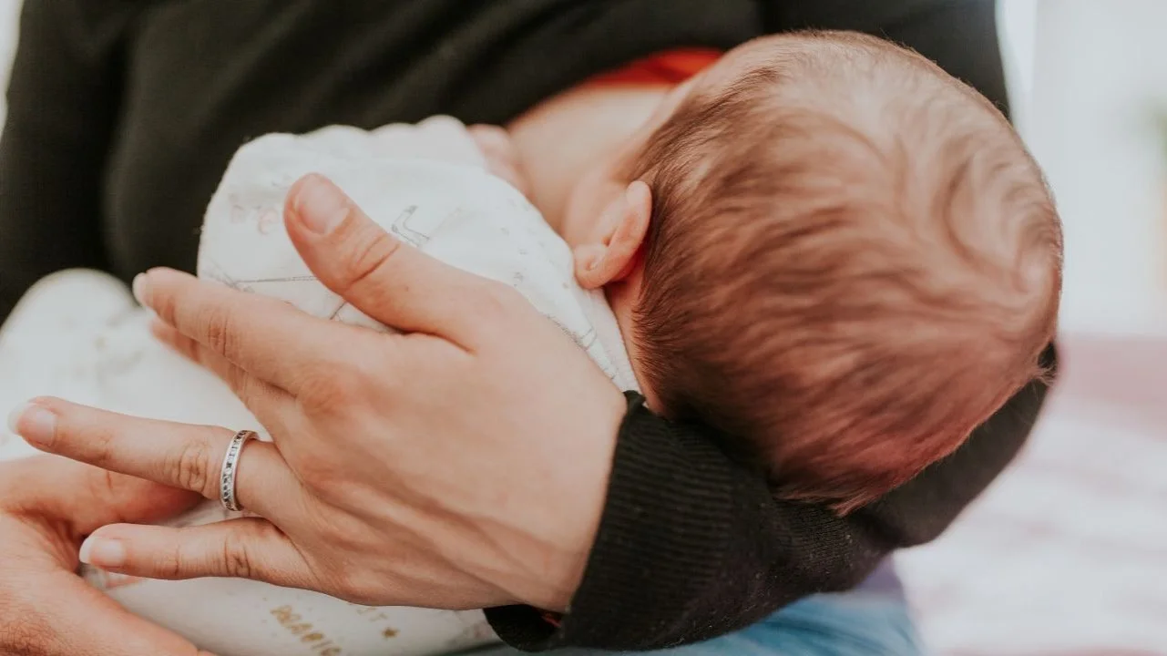 back of baby's head close up while breastfeeding