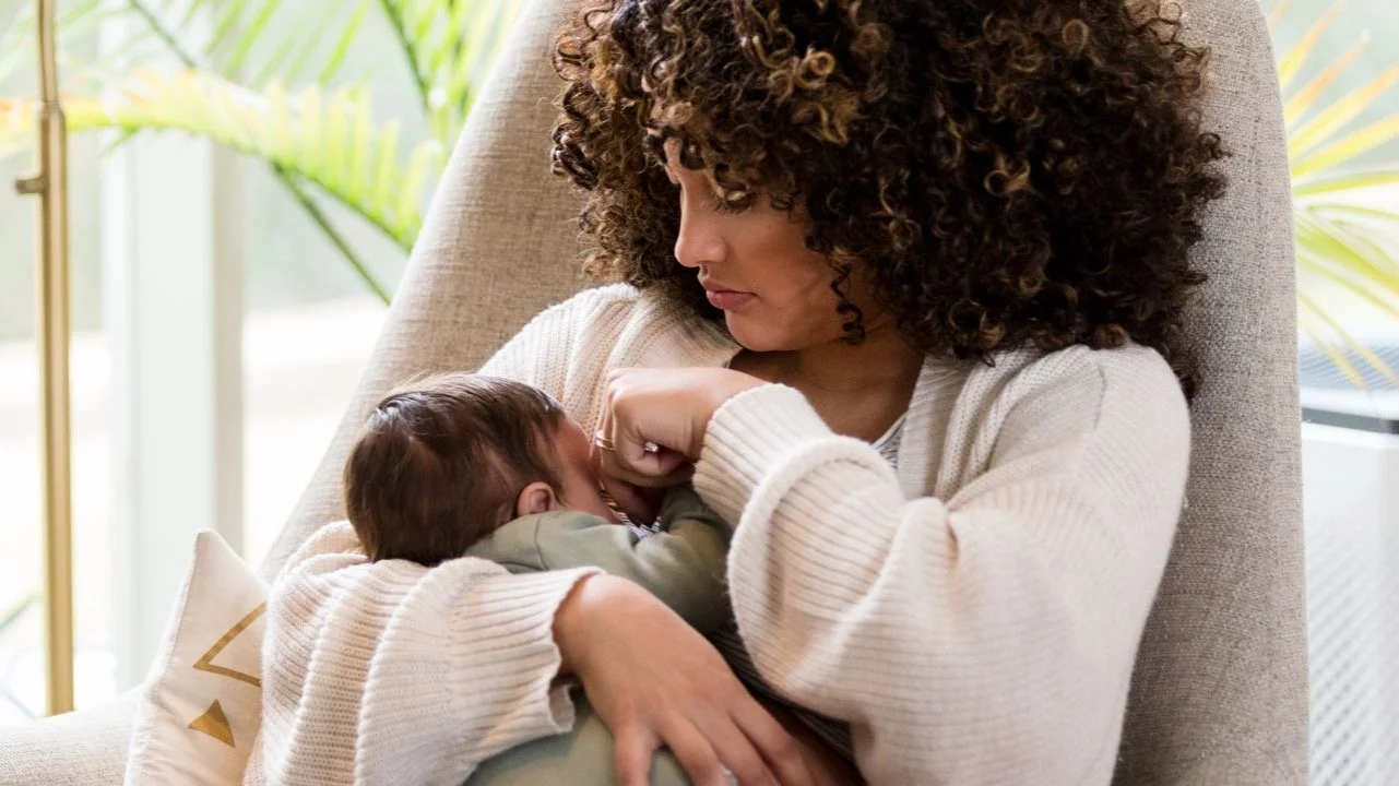mom rocking baby in rocking chair