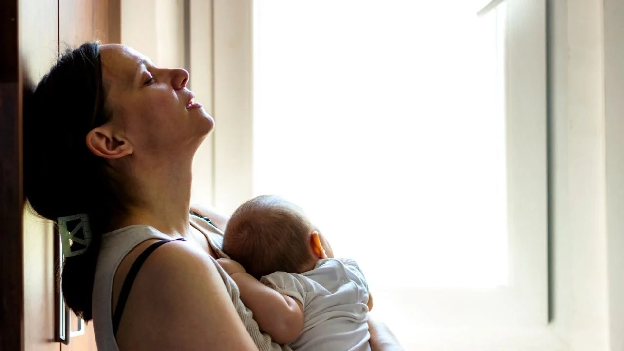 tired mom holding baby