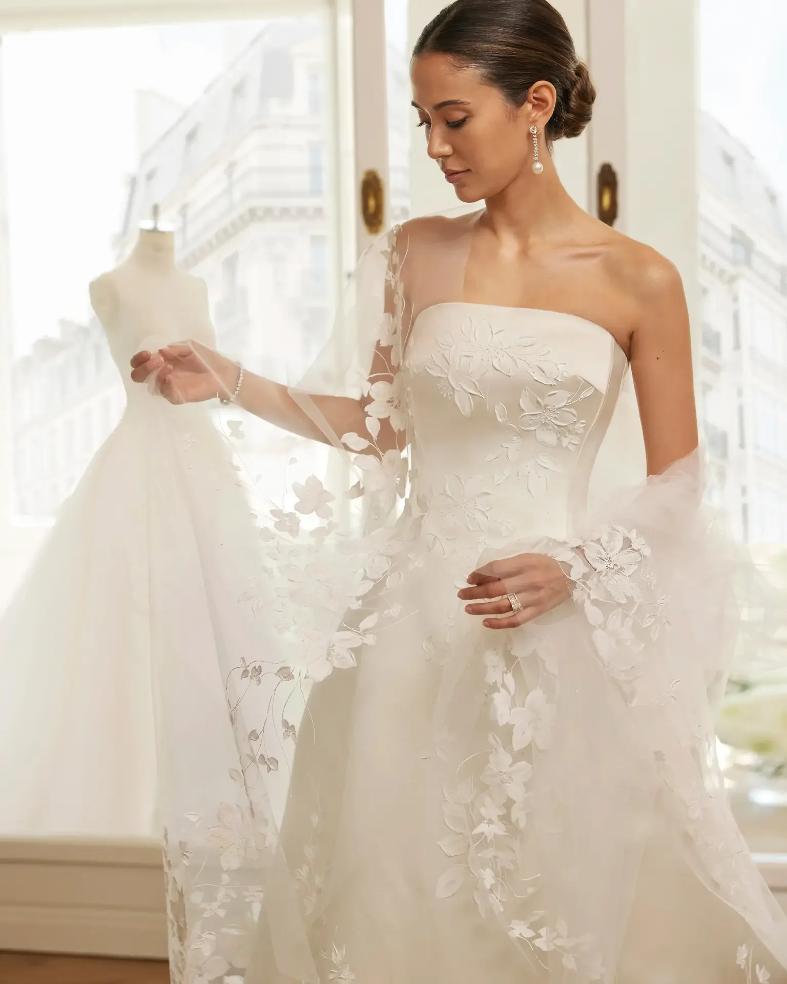 Bride standing in dressing room preparing for her wedding in a hand painted silk satin princess Ballgown Ashley and Alexandrias bridal atelier Oakland County Michigan