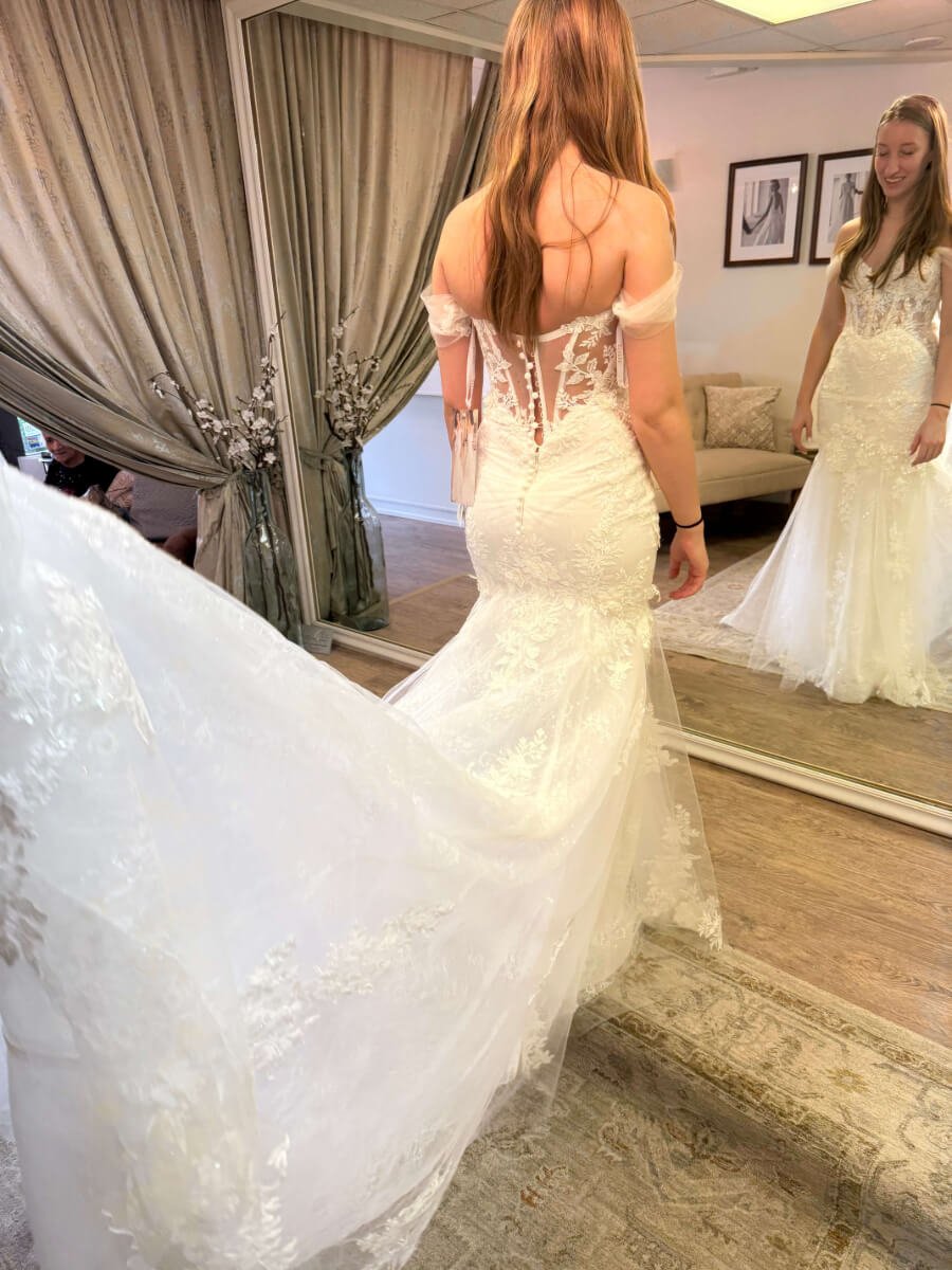 Bride admiring the wedding dress she imagined as her vision for the wedding fit and flare by Enzoani bridal in Metro Detroit Ashley and Alexandrias bridal Atelier Southfield Michigan