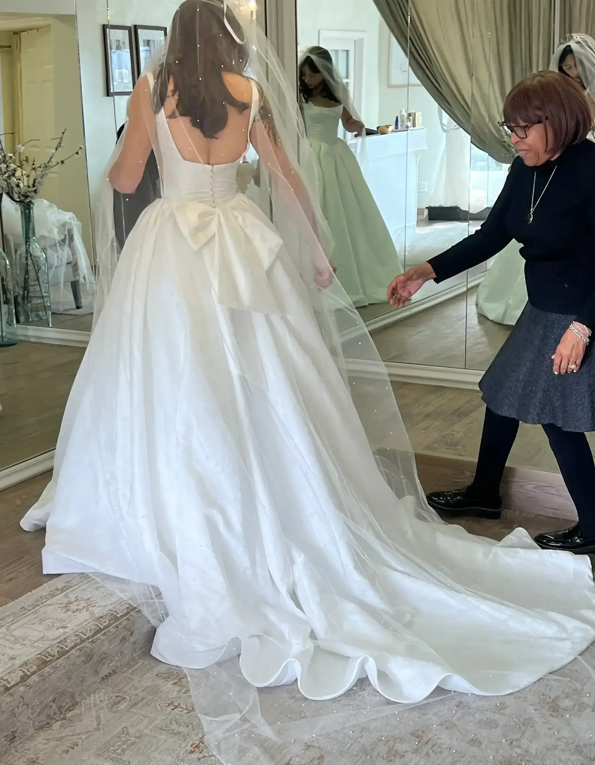 Bride Discovering how well she looks with the assistance from the bridal stylist Ashley And Alexandrias Bridal Atelier Clarkston Michigan
