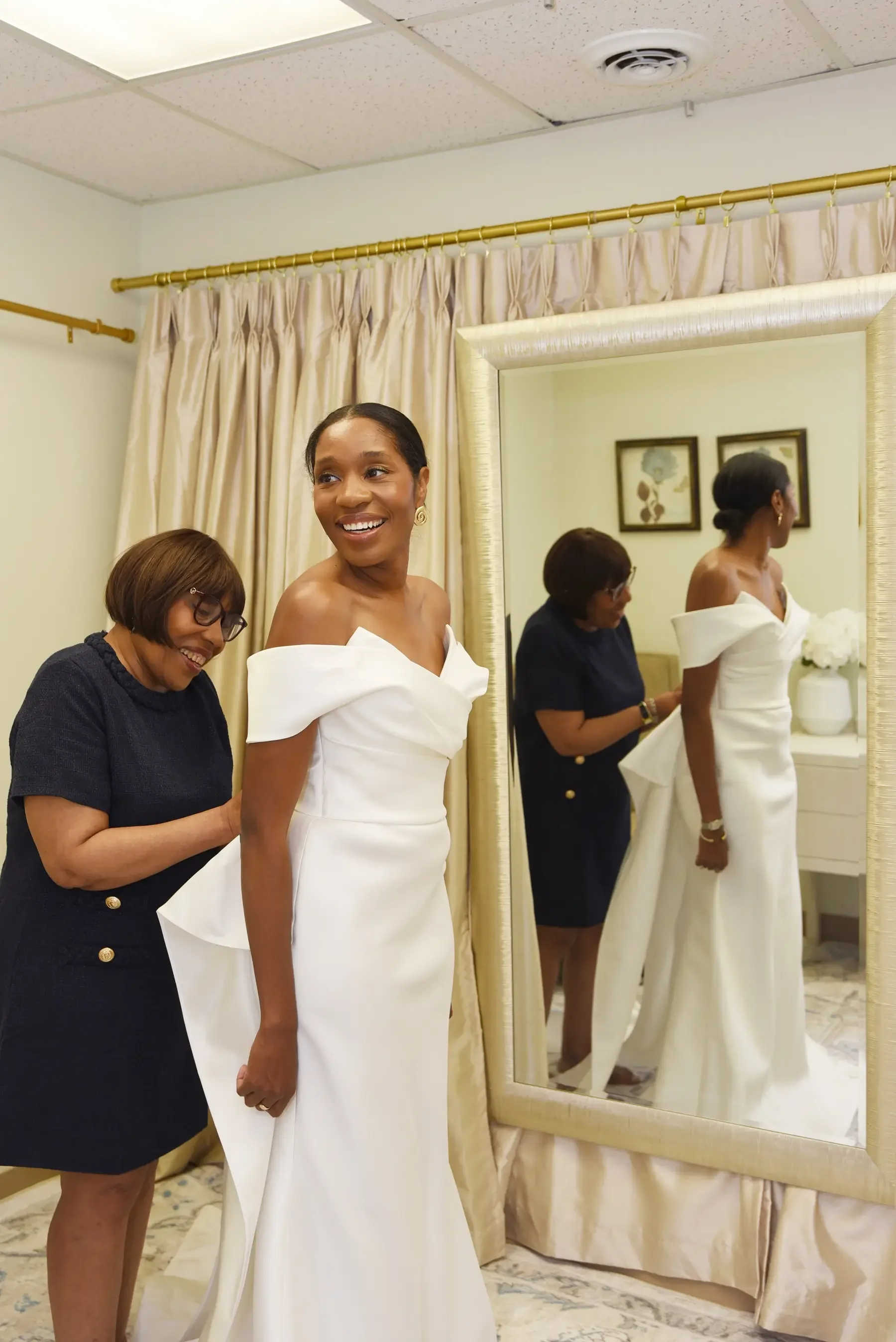 Bride Discovering how well she looks with the assistance from the bridal stylist at Ashley And Alexandrias Bridal Atelier Detroit Michigan