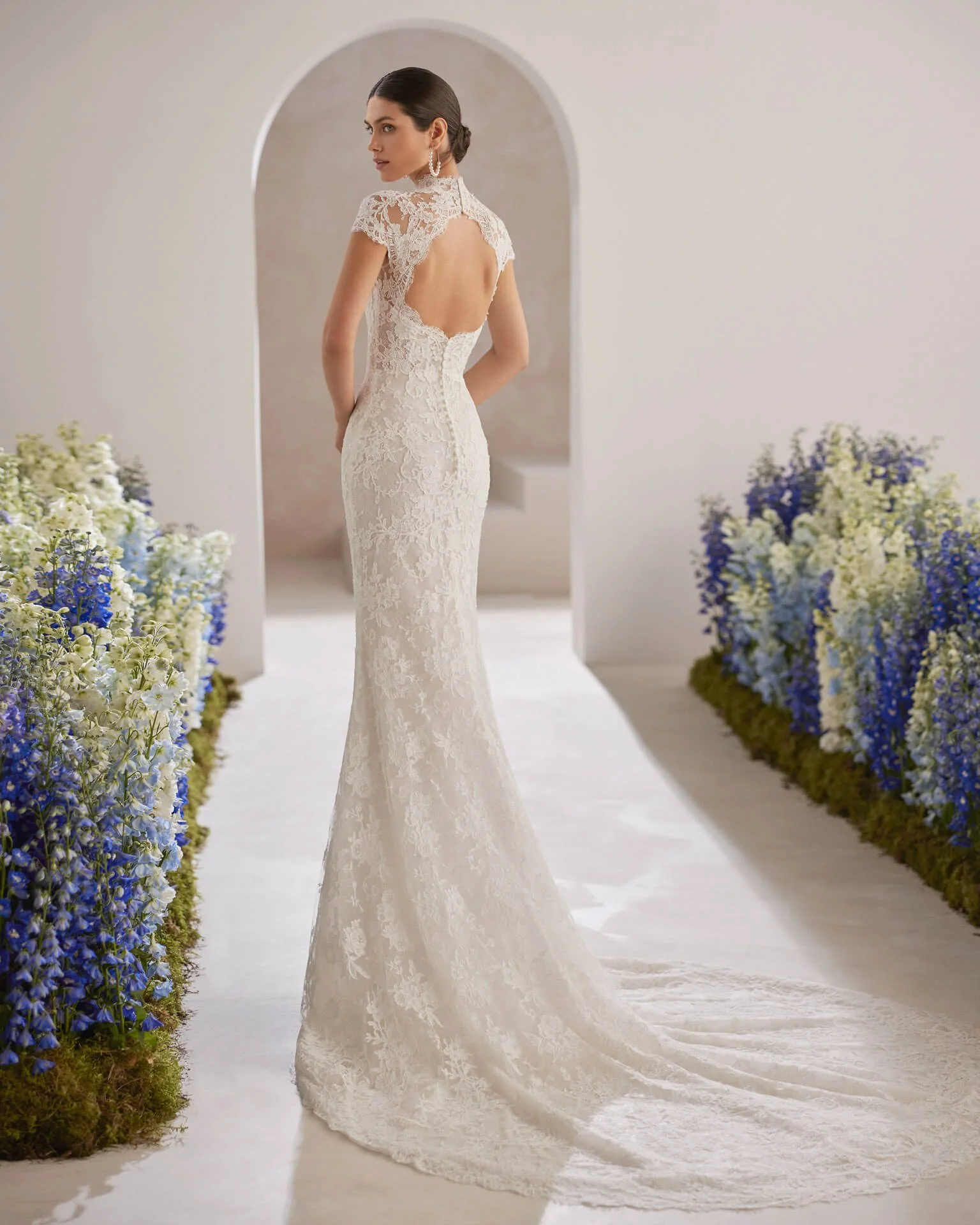 Bride in a hallway with flowers wearing a  Rosa Clara Couture Fit and Flare lace wedding dress Ashley and Alexandrias bridal Atelier  Michigan