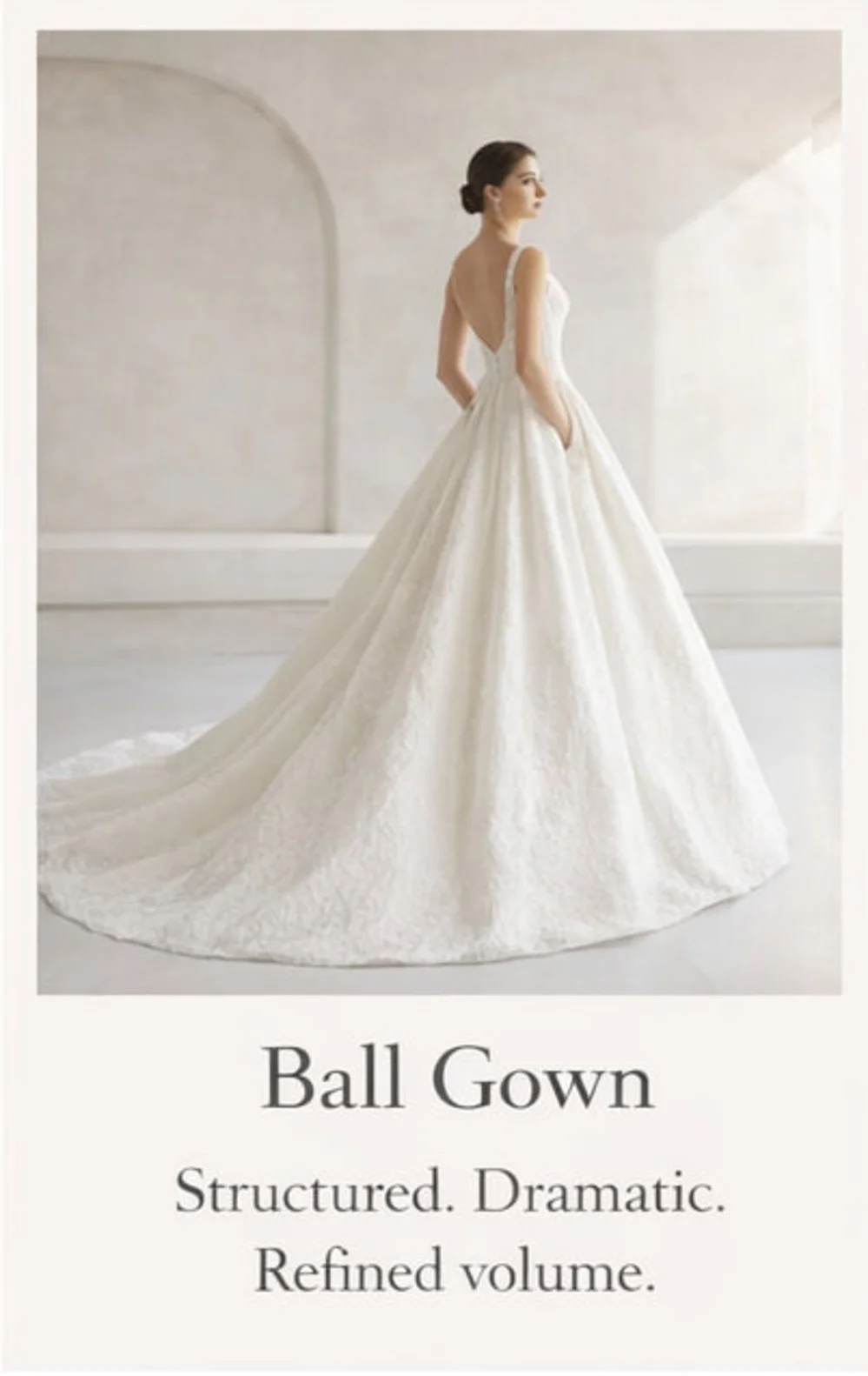 A woman in a wedding dress with a full skirt, standing in a minimalist, light-colored room.