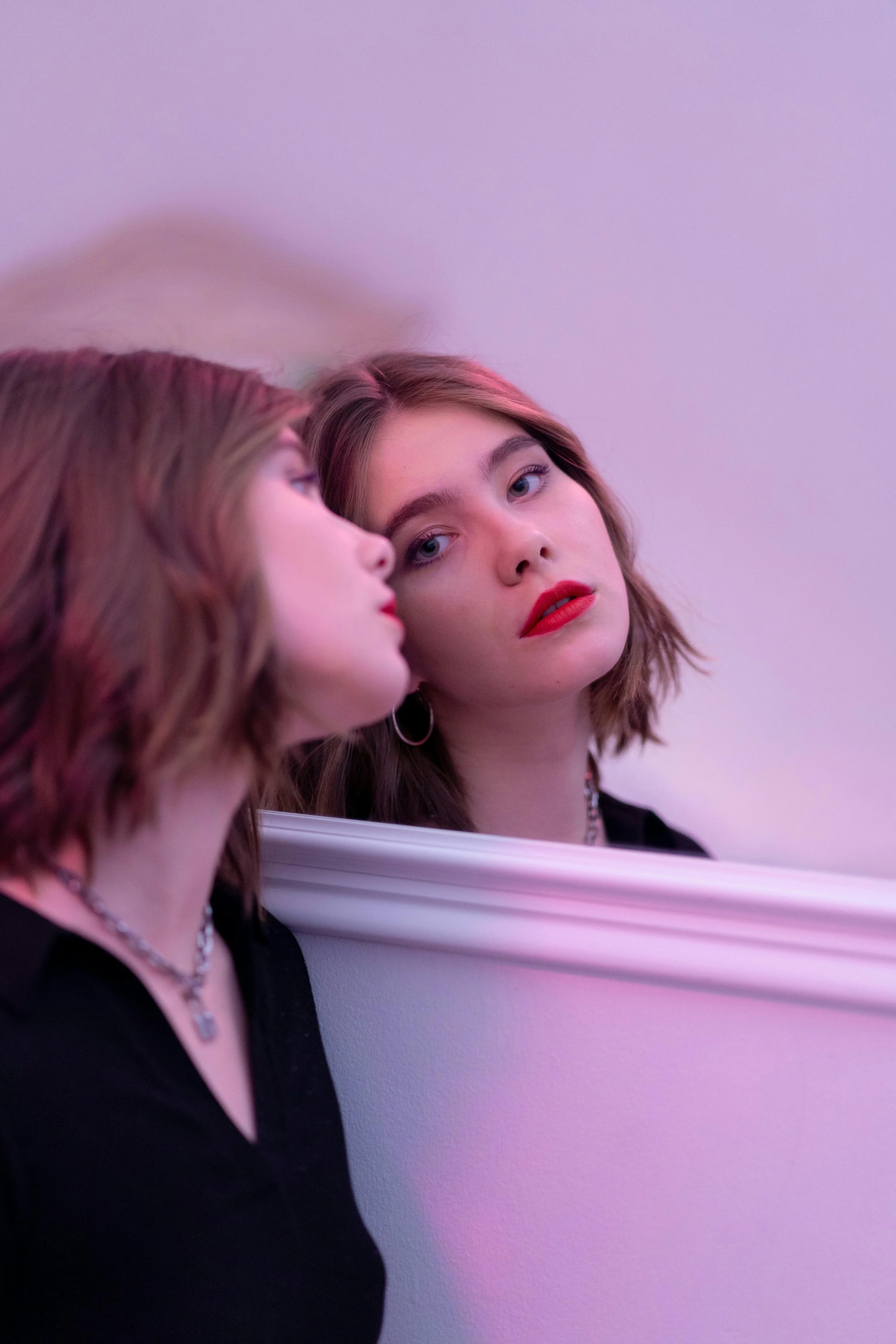a girl looking in the mirror at her reflection