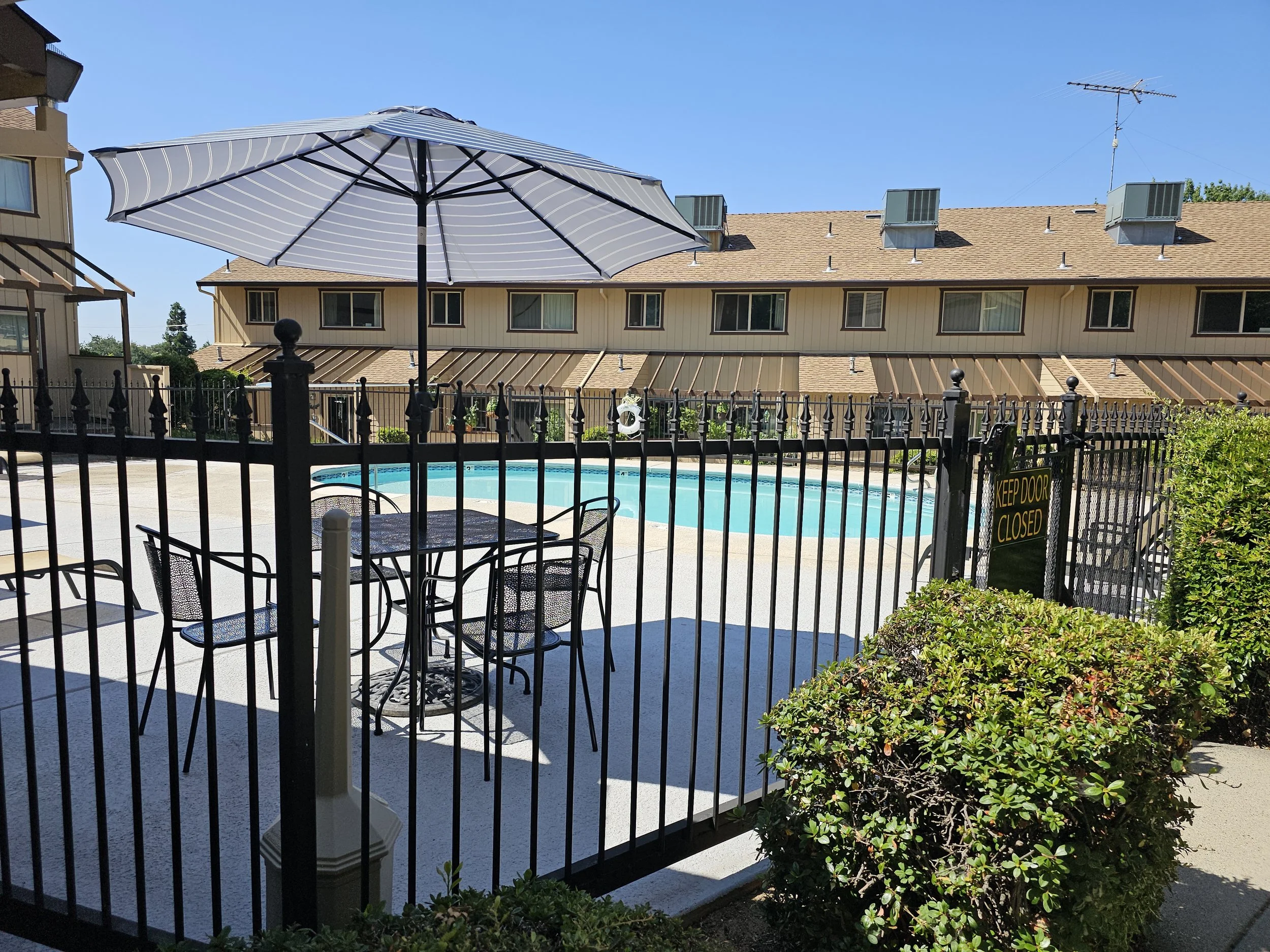 Table and chairs behind pool area gate