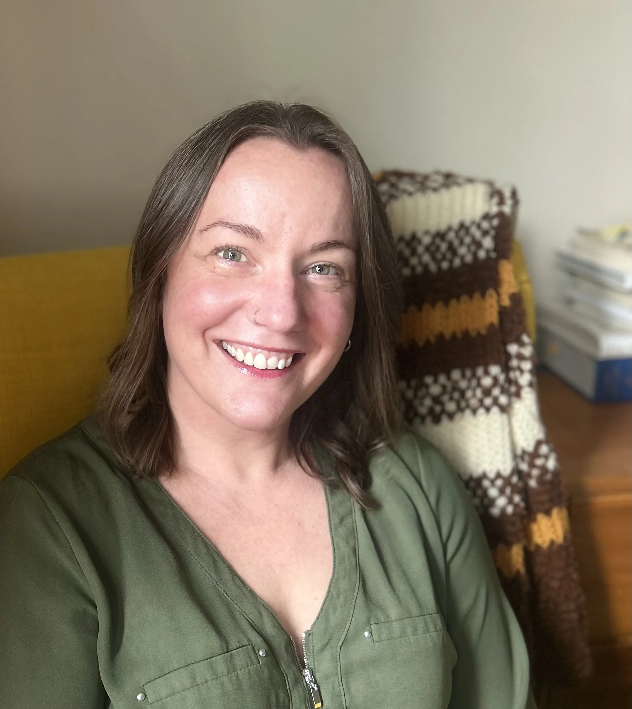 Stephanie Pauline Brooks with Pauling Editing sitting on yellow chair smiling
