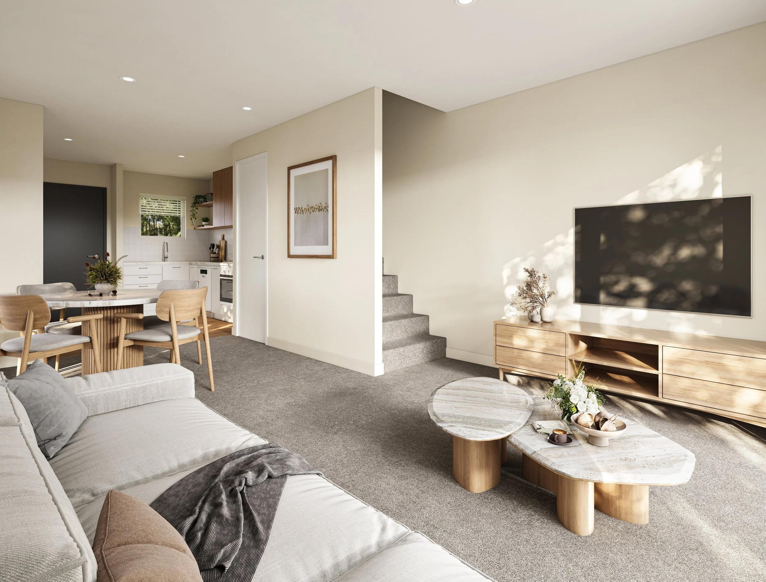 Living room with beige walls, gray carpet, and modern furniture, including a beige sofa with pillows, a marble coffee table, and a wooden TV stand with a large flat-screen TV. There is a staircase and a dining area with a round table and wooden chair