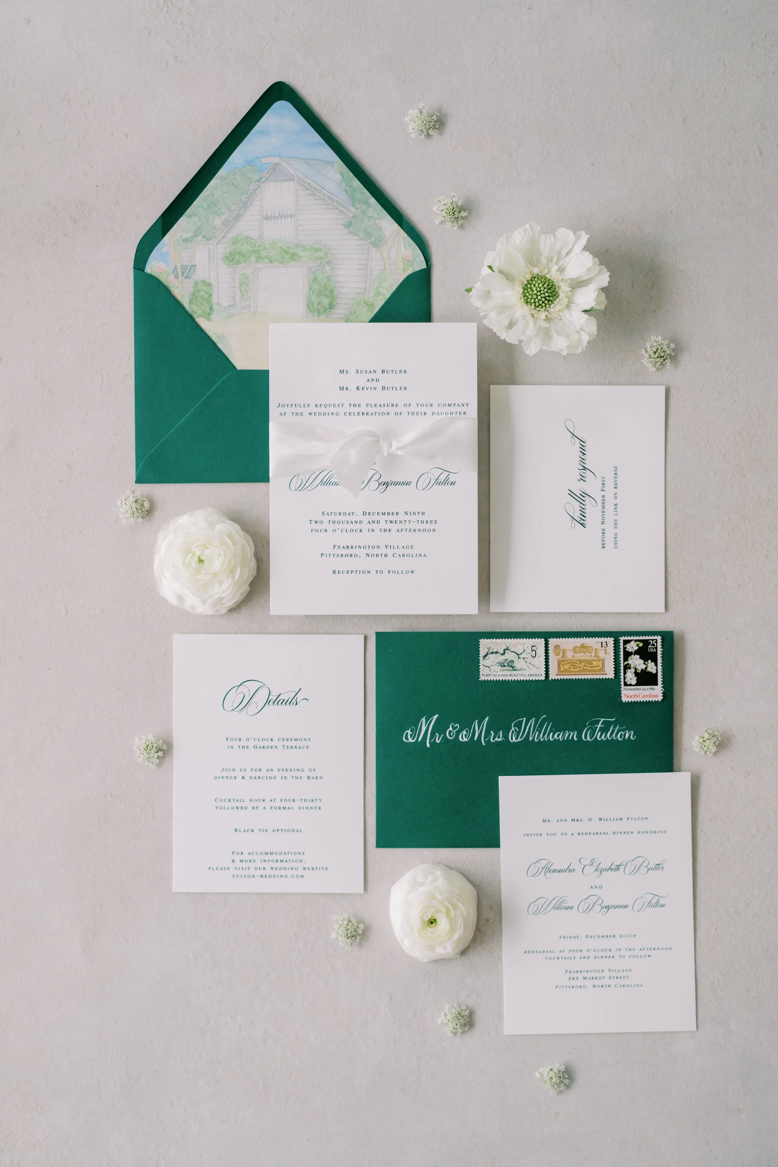 custom wedding invitations with emerald green thermography and blind embossing for Christmas winter wedding. Watercolor venue painting on envelope liner, while silk ribbon, gold wax seal and corresponding details cards