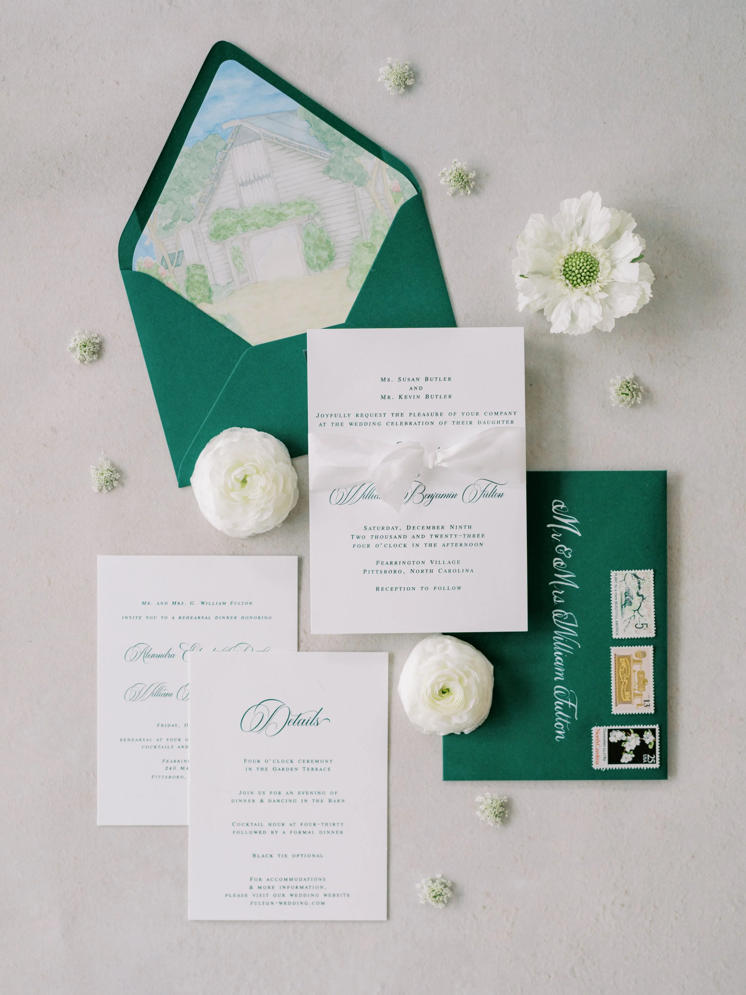 custom wedding invitations with emerald green thermography and blind embossing for Christmas winter wedding. Watercolor venue painting on envelope liner, while silk ribbon, gold wax seal and corresponding details cards