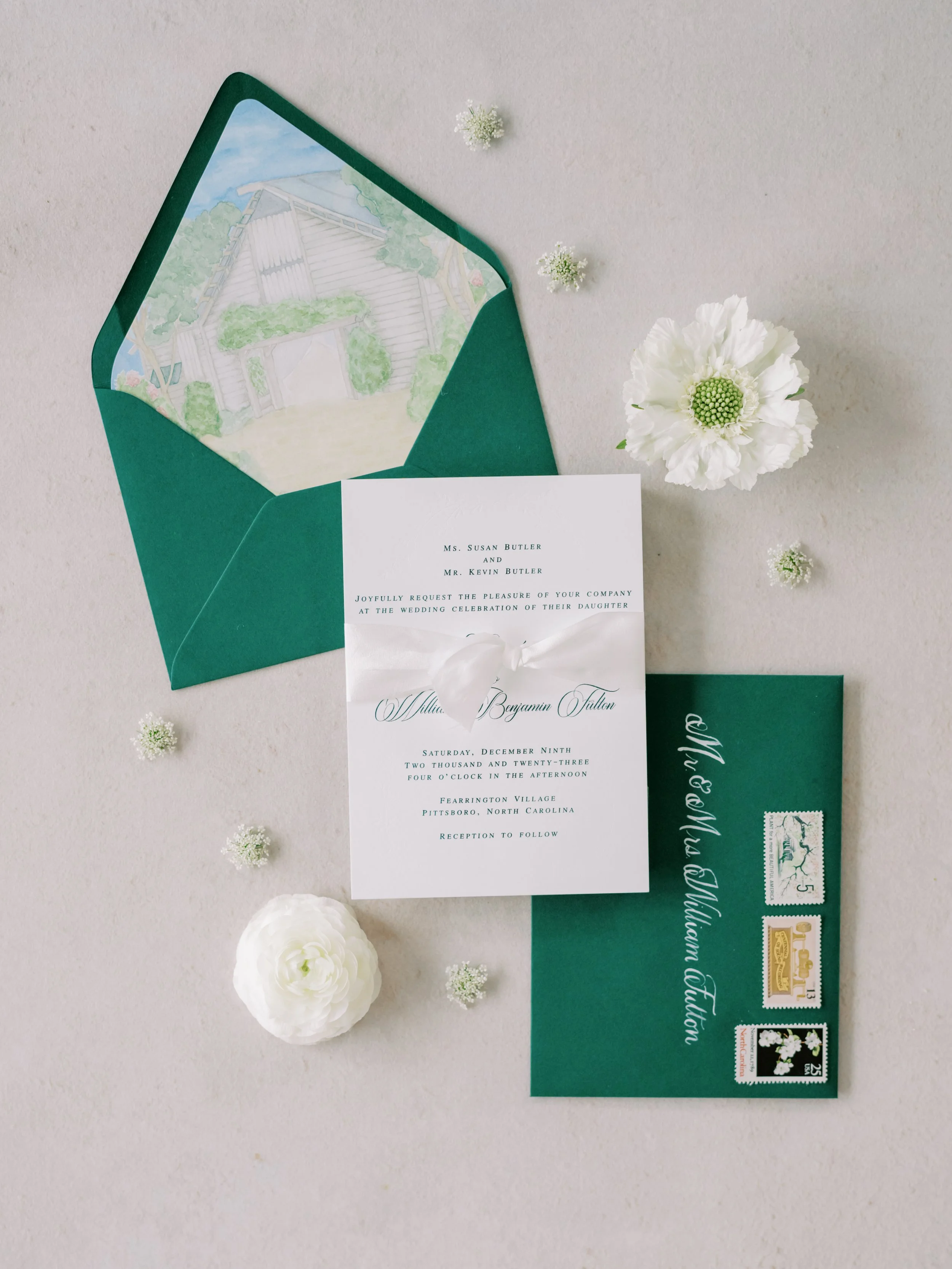 custom wedding invitations with emerald green thermography and blind embossing for Christmas winter wedding. Watercolor venue painting on envelope liner, while silk ribbon, gold wax seal and corresponding details cards