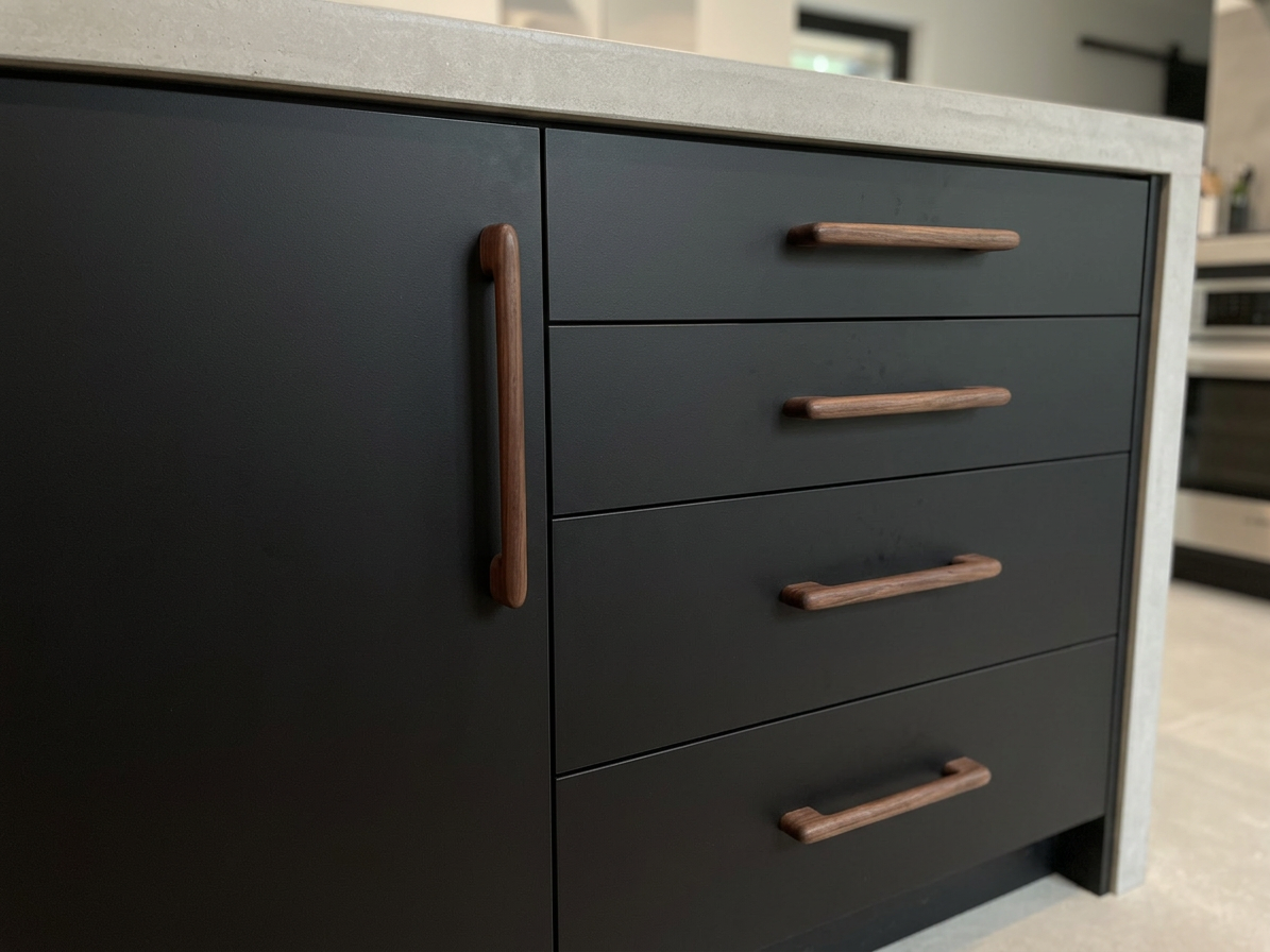 Walnut pulls on a black kitchen leaf furniture.png