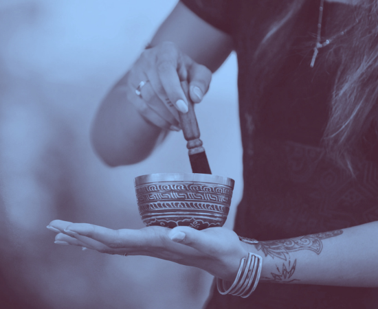 Person holding a bowl and stirring it with a wooden spoon.