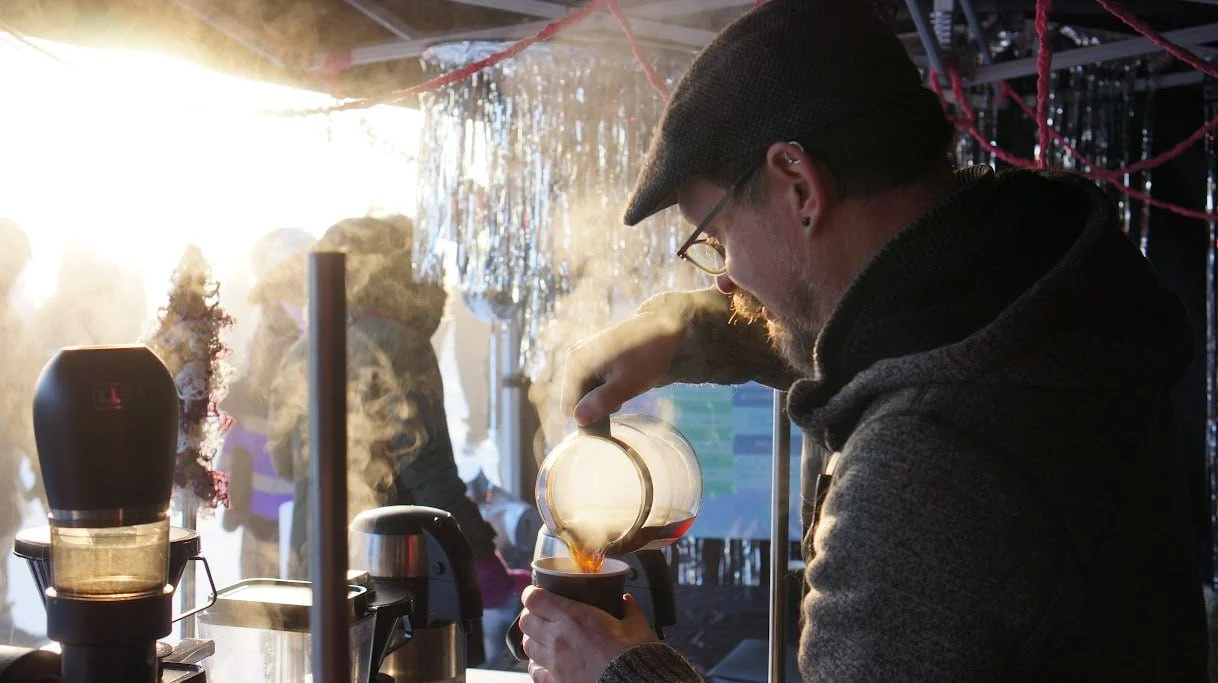 Matthew is outside, by his coffee cart, serving customers in the fog