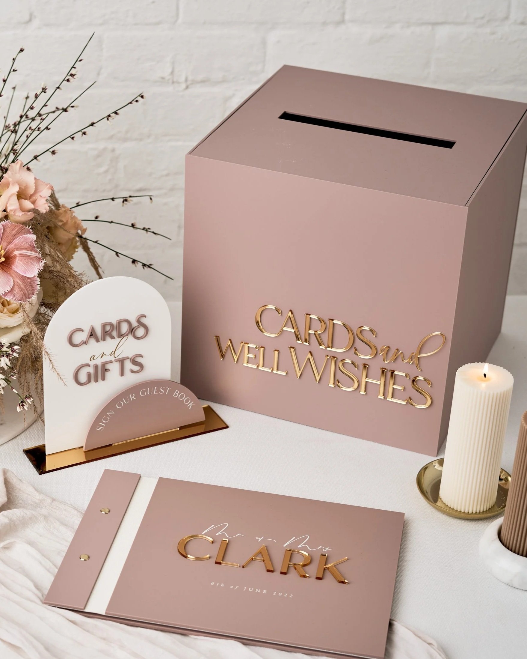 Wedding signage with personalized cards and messages on a decorated table with candles.